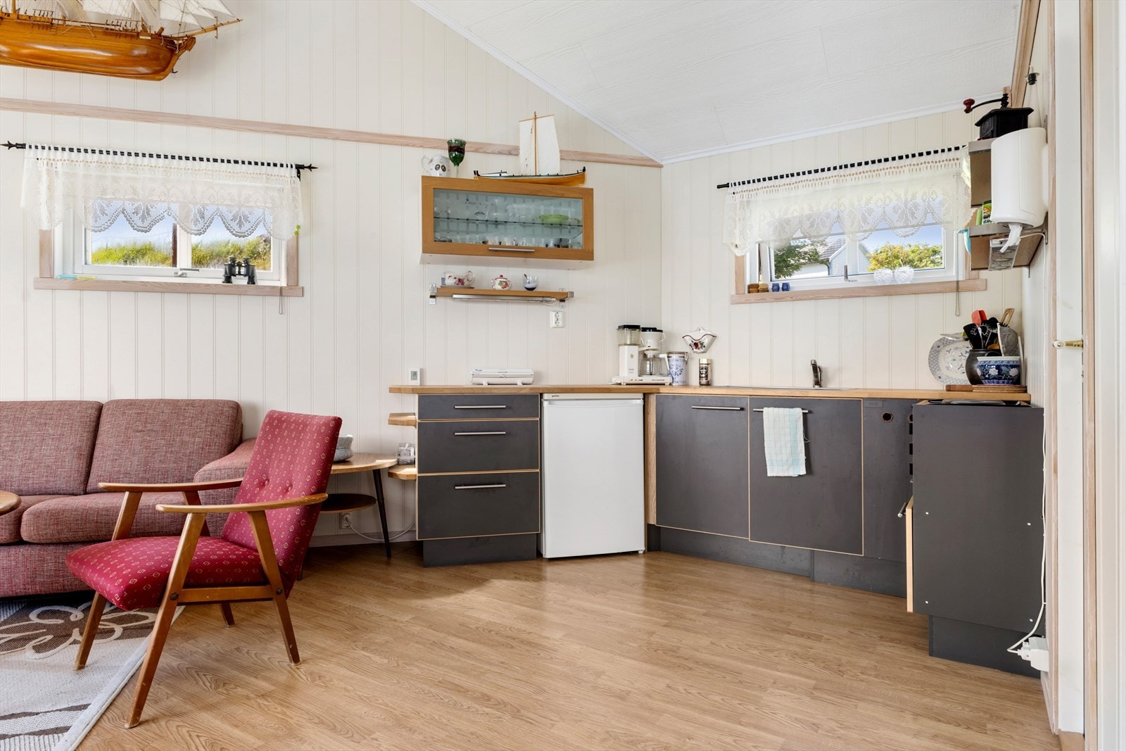 Kjøkken. Laminerte skrog med slette skapfronter. Heltre benkeplater. Oppvaskkum av stål med ett-greps blandebatteri. Hybelkomfyr. Ingen avtrekk over koketoppen. Varmtvannsbereder. Galleribilde