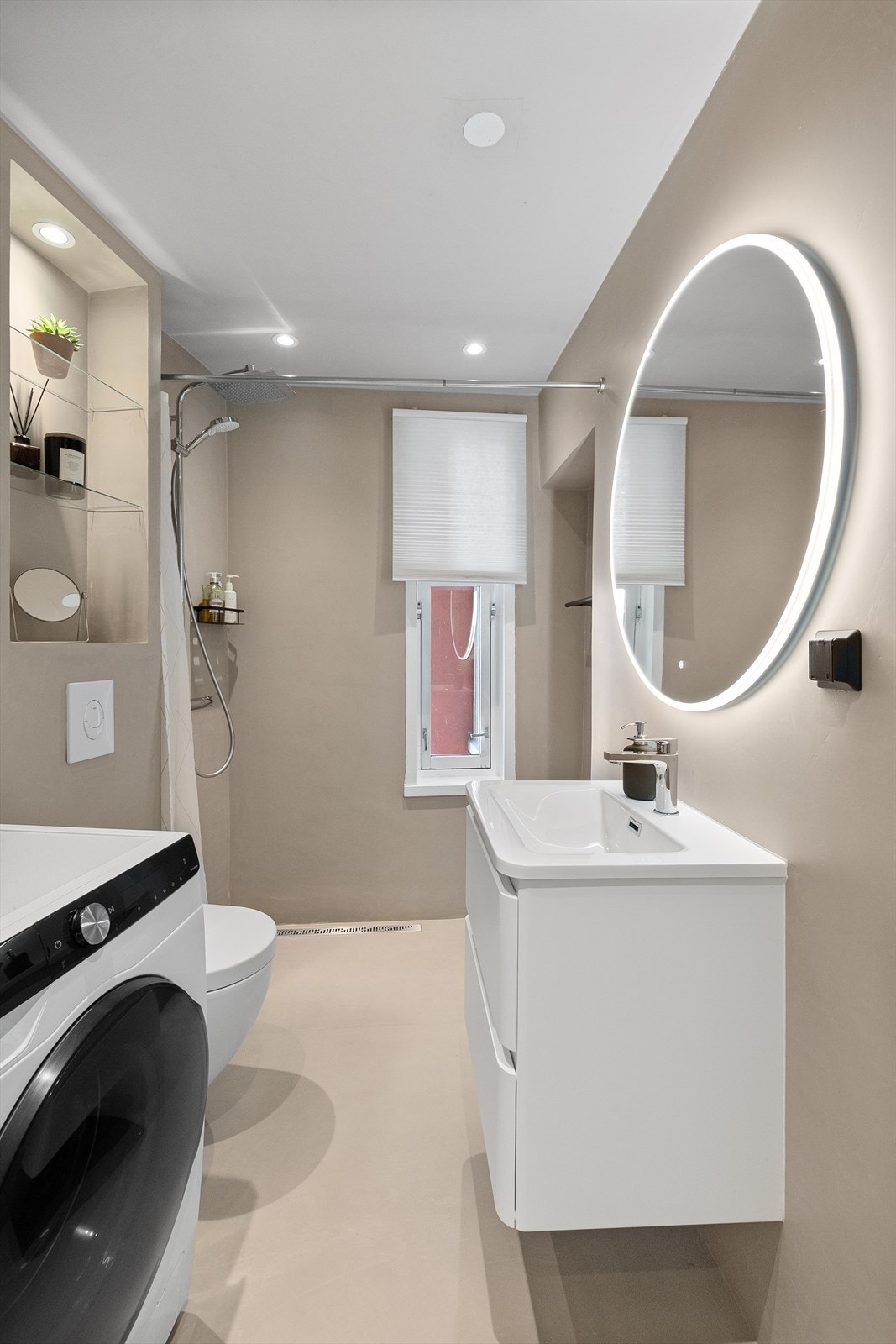 Lekkert bad pusset opp i 2023 med bl.a. mikrosement og ny innredning. Baderommet inneholder veggmontert toalett, dusjhjørne med regnfallsdusj og baderomsinnredning med skuffer, servant og speil med belysning. Galleribilde