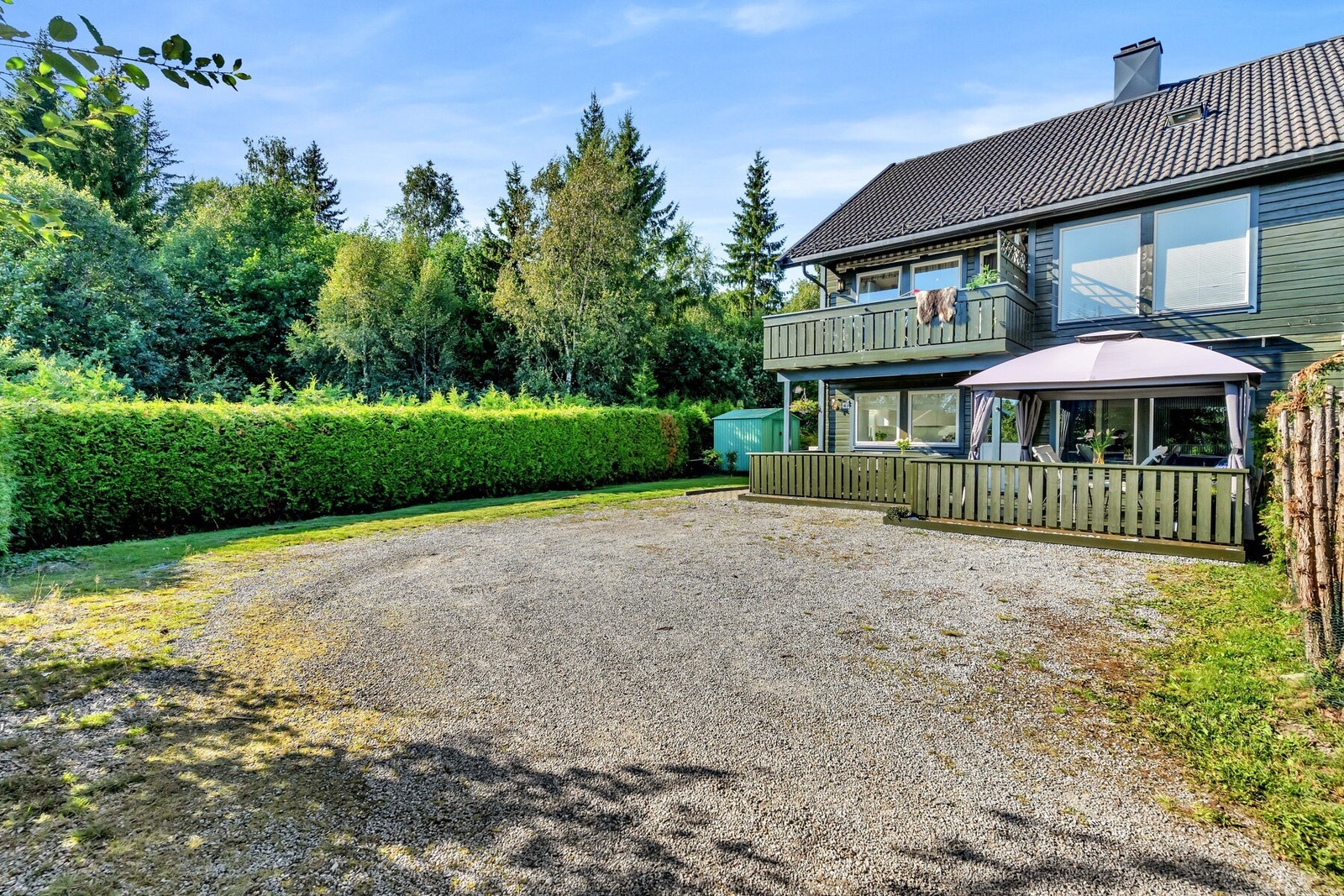 På den grusede gårdsplassen foran huset finner du parkeringsmuligheter. Det er kort vei fra bilen og inn til inngangsdøren, som er praktisk i en travel hverdag. Galleribilde