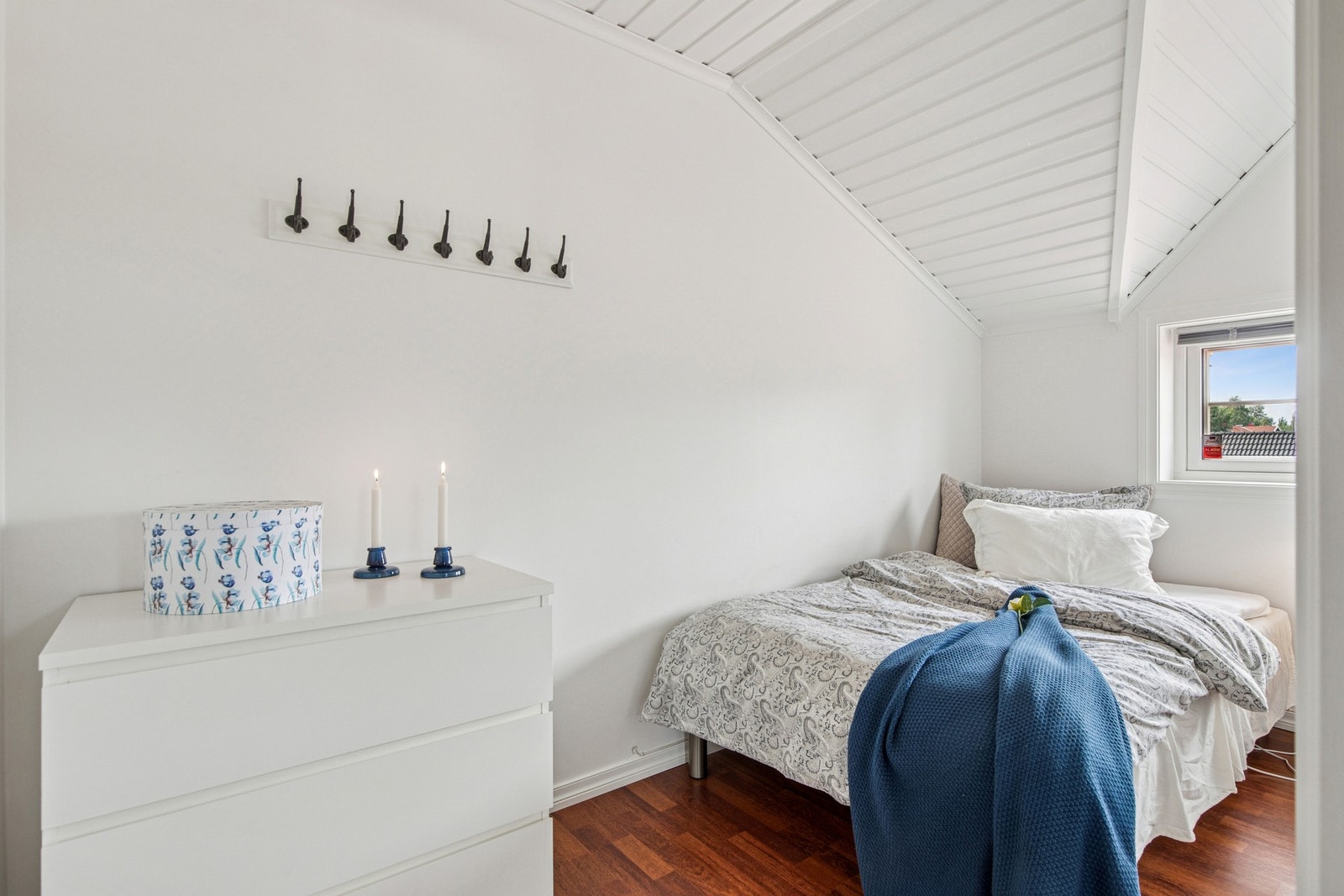 Videre har vi et lyst og enkelt innredet rom med skråtak og vindu som slipper inn godt med dagslys. Galleribilde