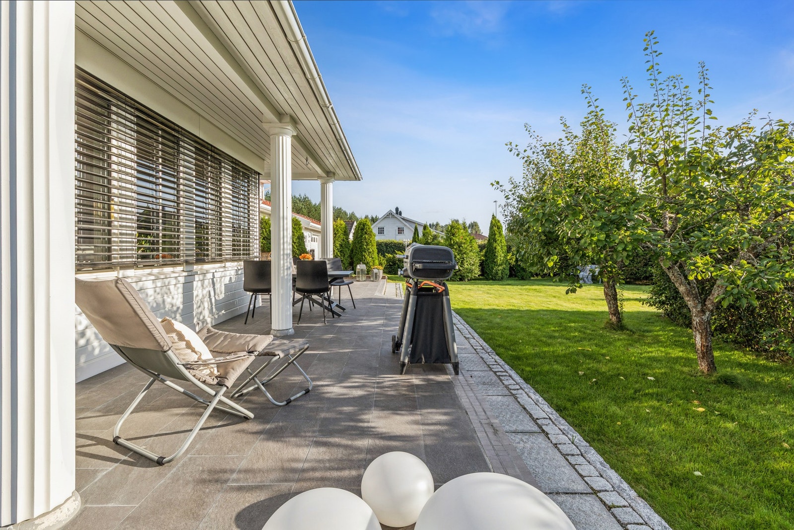 Videre har eiendommen en solrik hage med frodige frukttrær som rammer inn uteplassen og gir en hyggelig atmosfære. Galleribilde
