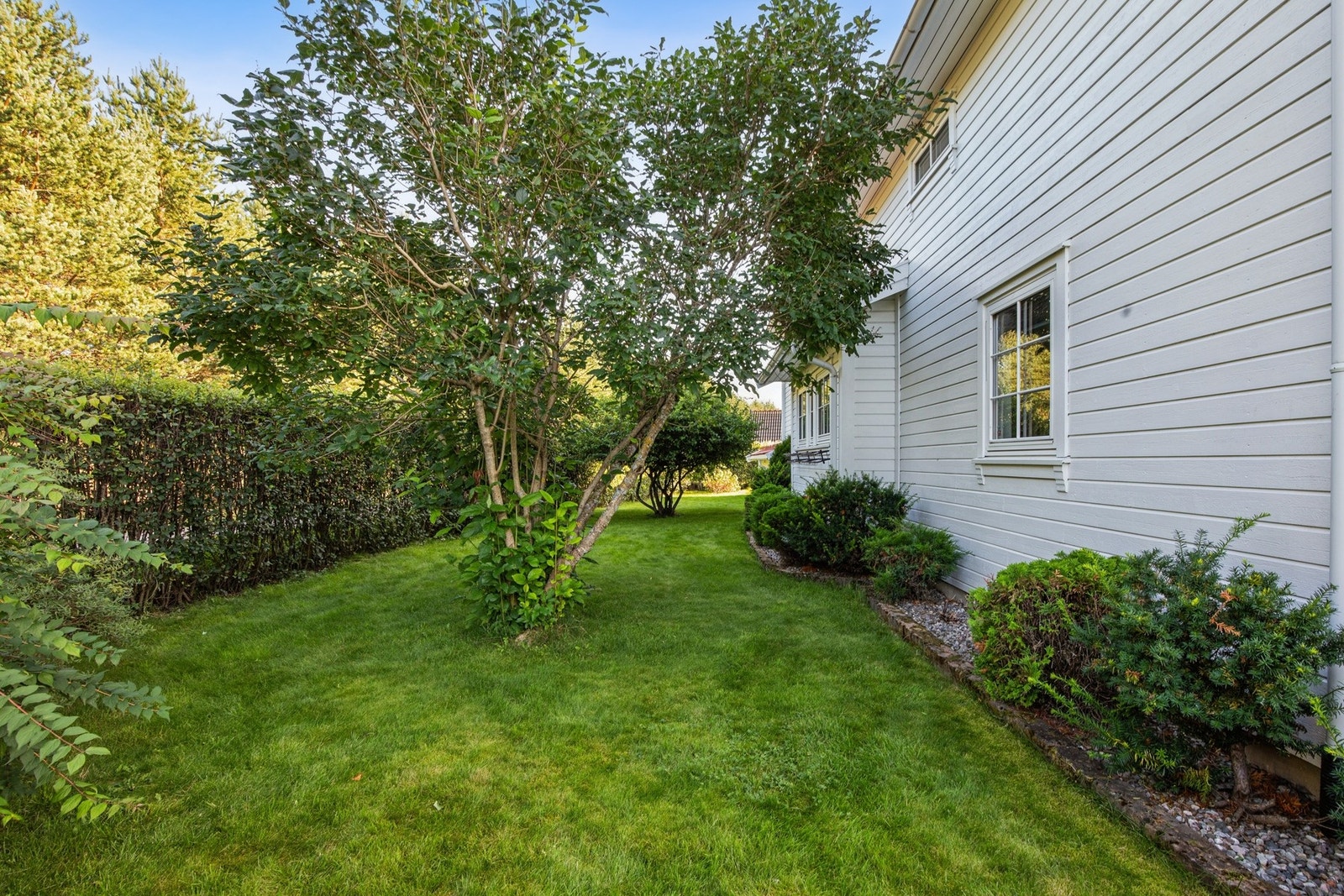 Hagen omkranses av frukttrær, prydbusker og lune uteplasser som inviterer til rolige stunder og hyggelige sammenkomster. Galleribilde