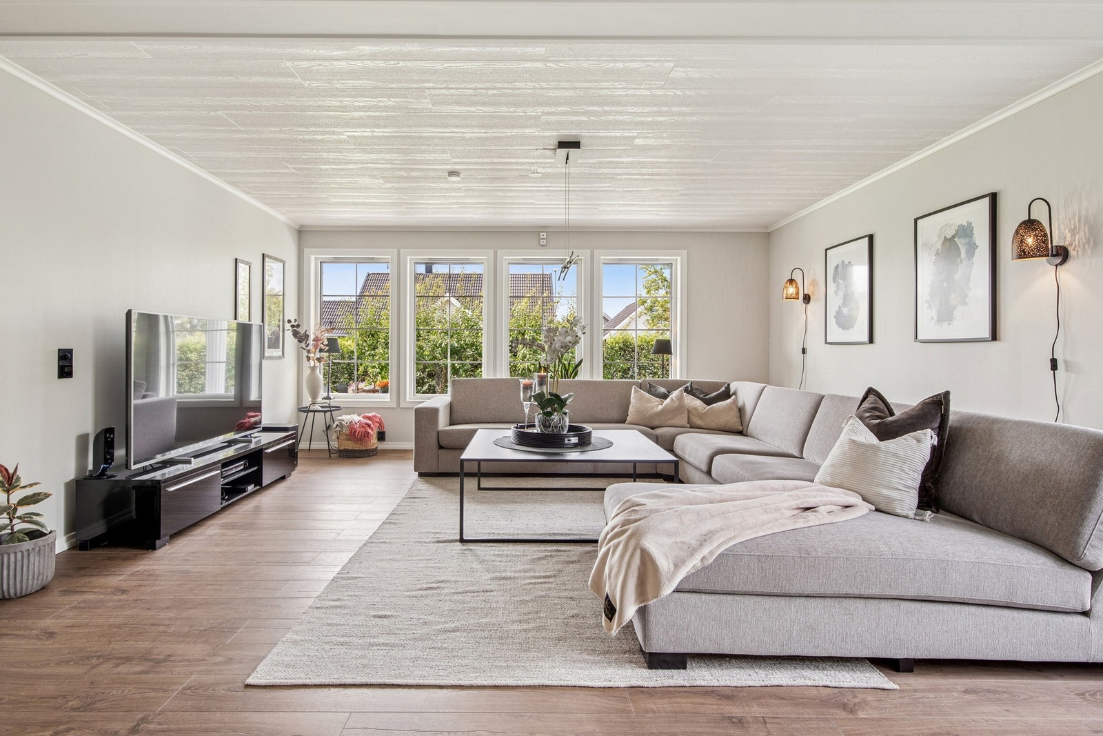 Store vindusflater slipper inn rikelig med naturlig lys og gir stuen en åpen og luftig atmosfære med flott utsyn mot hagen. Galleribilde