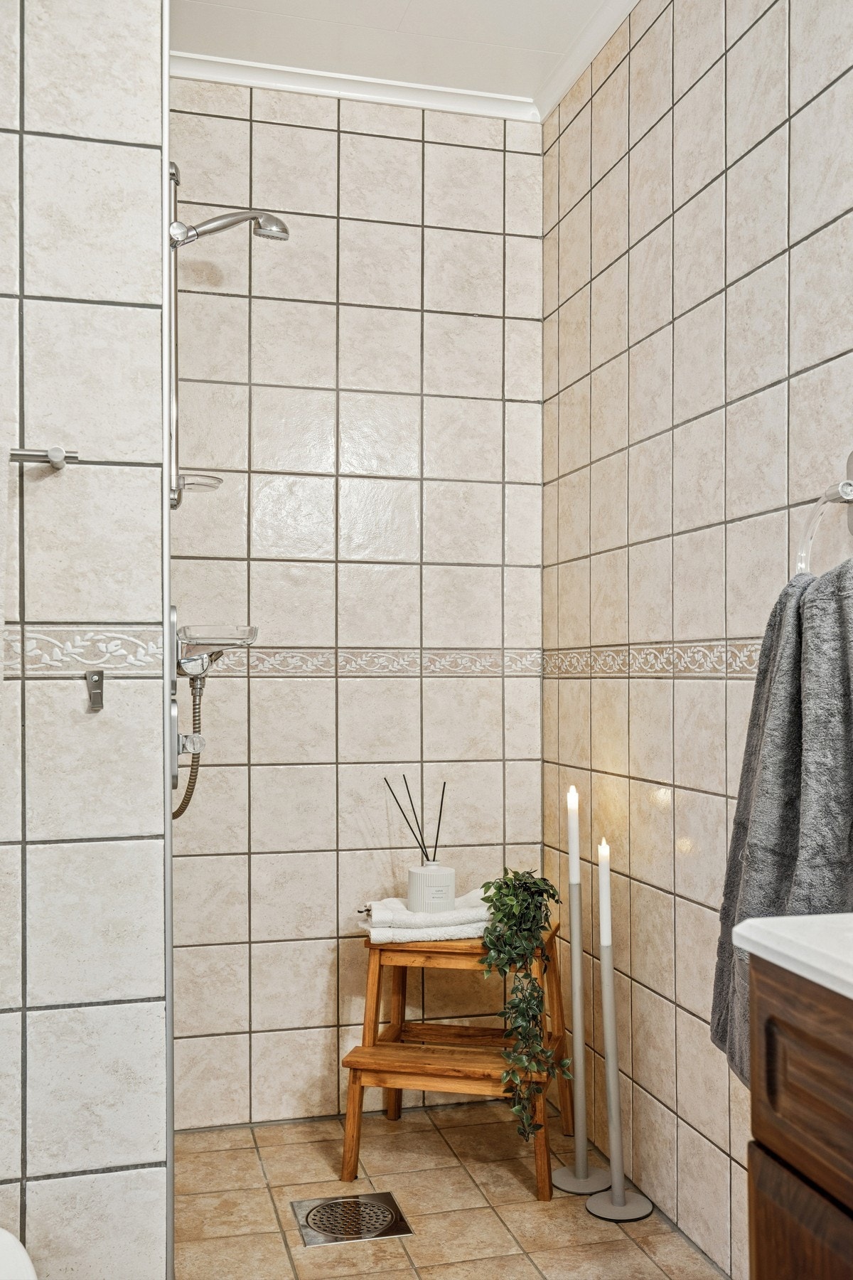 Videre har badet en praktisk dusjnisje, pent flislagt i samme stil som resten av rommet. Galleribilde