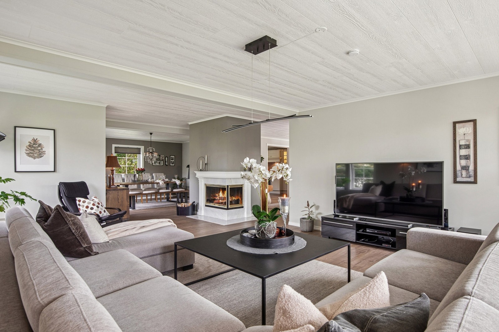 Stuen har en gjennomtenkt planløsning med plass til både stor sofagruppe og ekstra sitteplasser - ideelt for familieliv og hyggelige sammenkomster Galleribilde