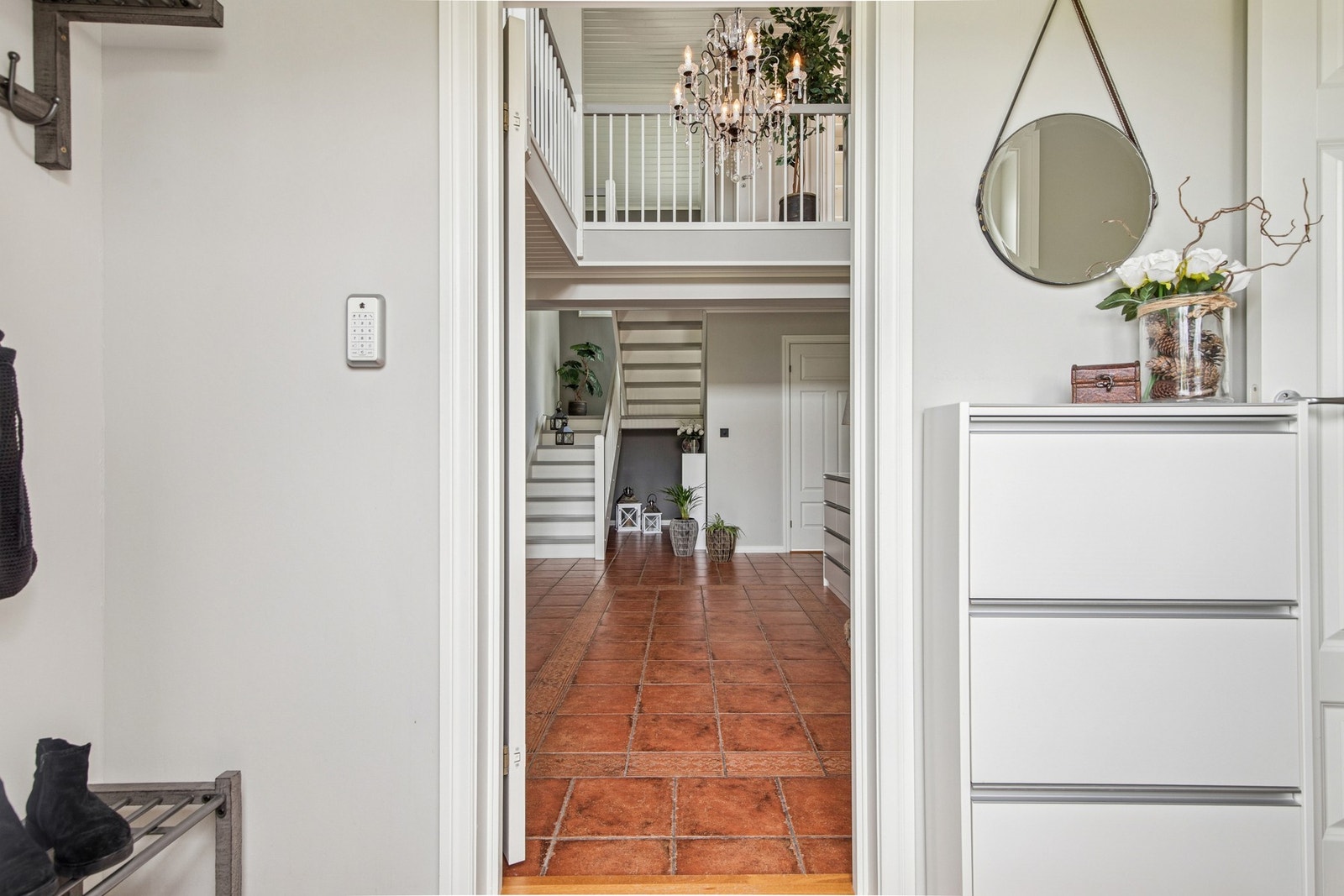 Vindfang med flislagt gulv og varmekabler, med adkomst videre til hall med åpen himling. Galleribilde