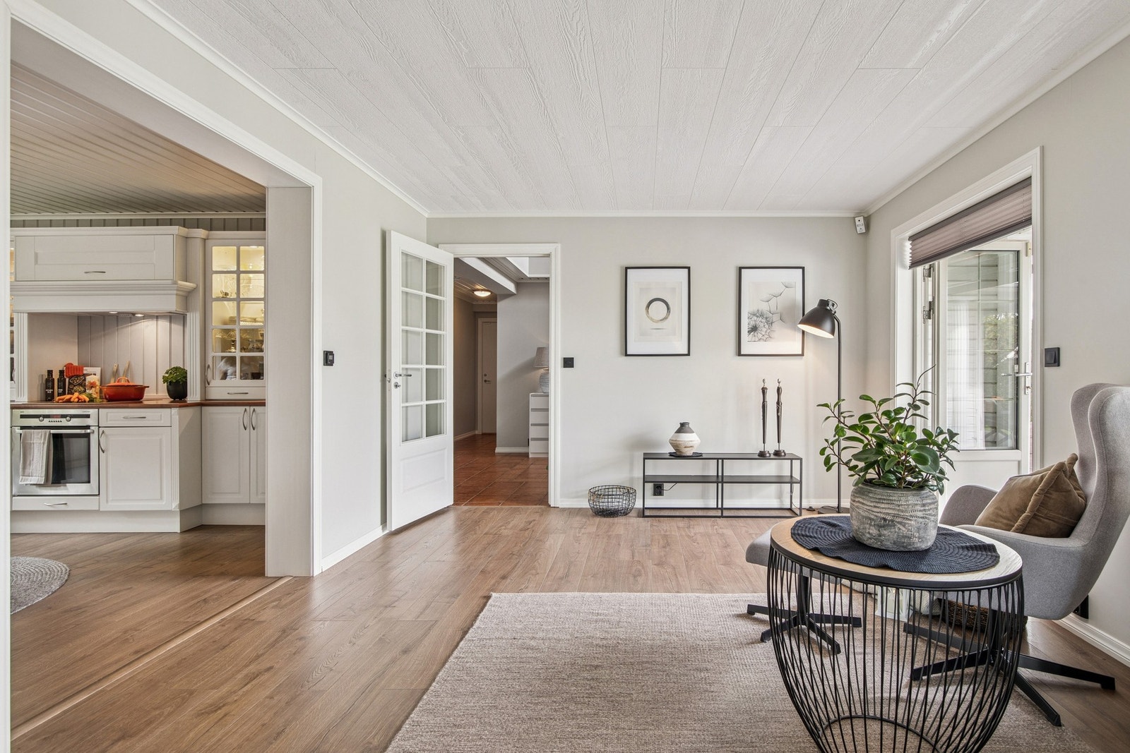 Videre trekker vi inn mot en trivelig mellomstue med god plass til flere møbleringssoner, store vindusflater og direkte adkomst til kjøkkenet. Galleribilde