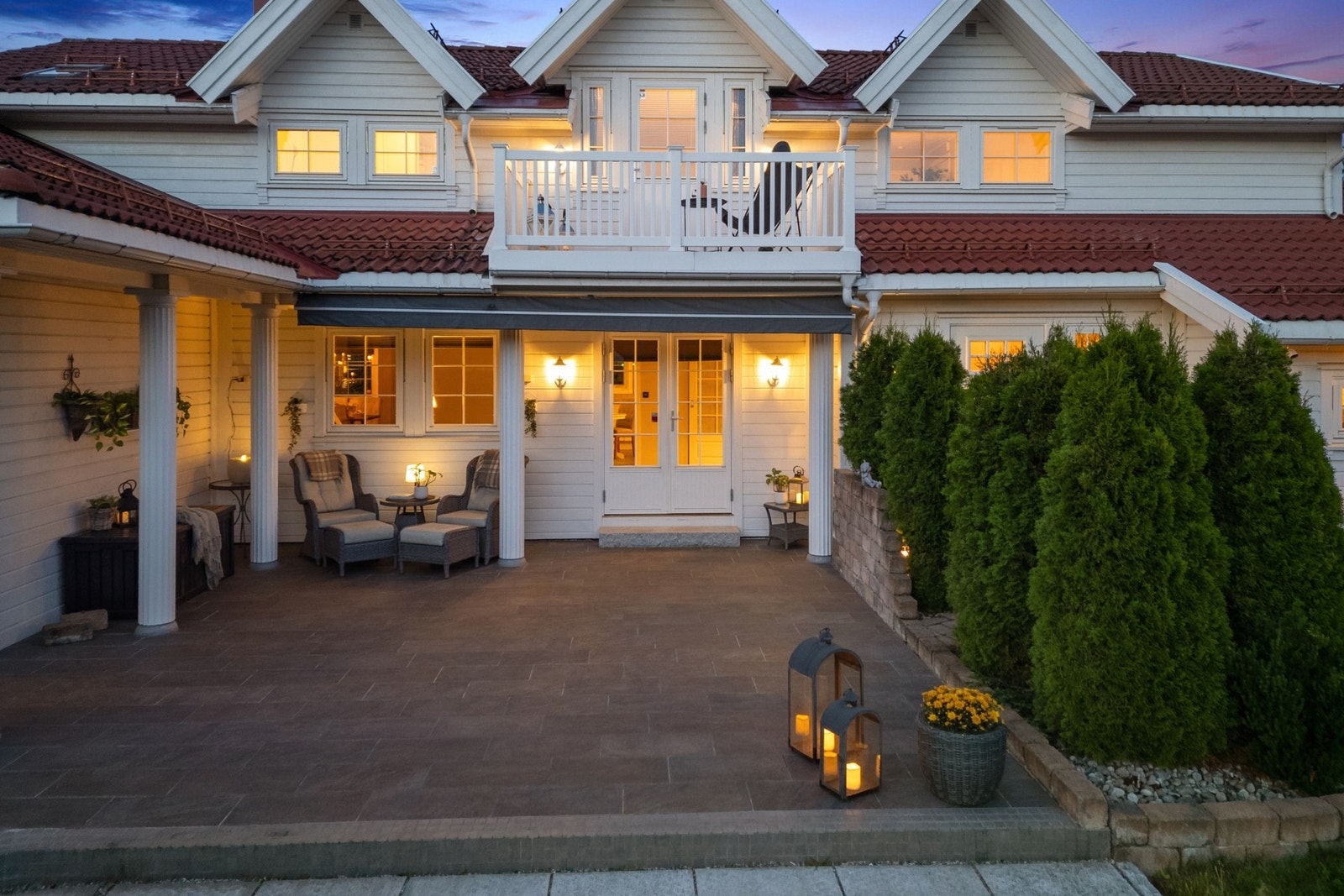 Flislagt terrasse bygget på isolert glasopor, med overbygget sitteplass og balkong i 2. etasje. Galleribilde