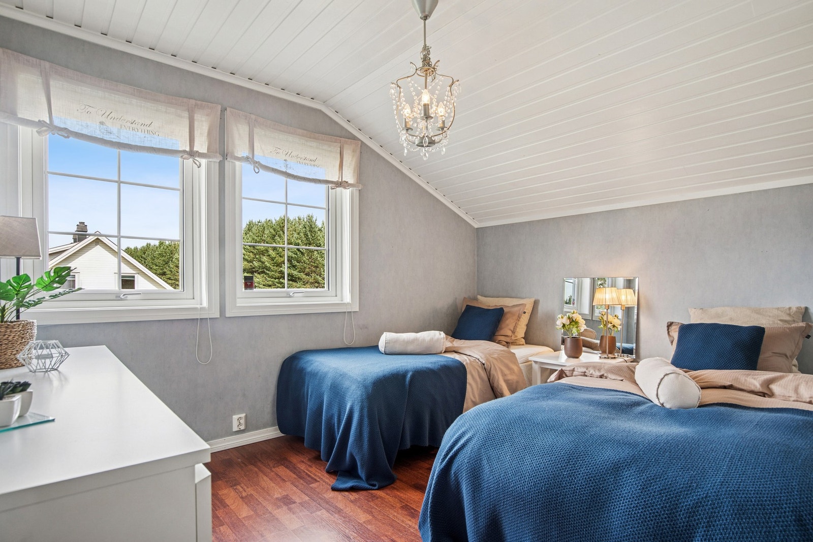 Videre inn i 2. etasje finner vi et lyst soverom med plass til to enkeltsenger eller eventuelt en dobbeltseng. De skrå himlingene og de store vinduene gir rommet en lun atmosfære samtidig som dagslyset slipper godt inn. Galleribilde