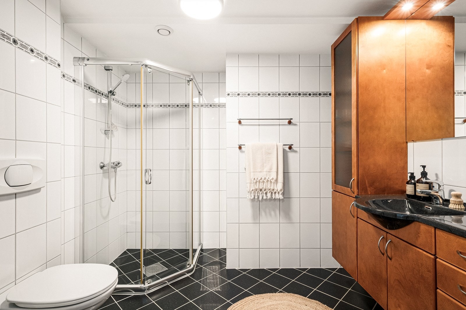 Badet er praktisk innredet med stor baderomsinnredning, dusjhjørne og vegghengt toalett Galleribilde