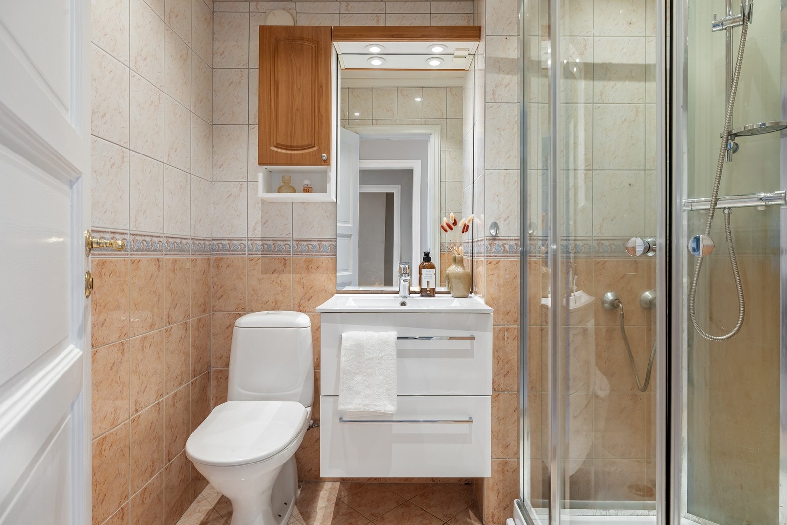 Badet på 3,5 kvm er helfliset med varmekabler i gulv og innfelte downlights i tak Galleribilde