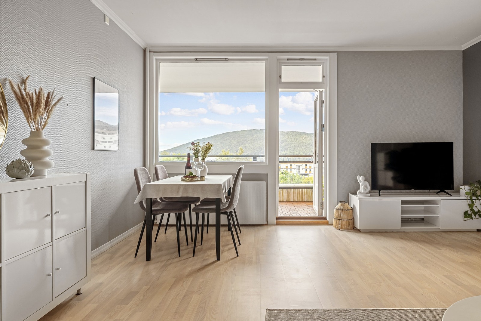 Vi beveger oss videre inn til hjertet av leiligheten, som er den lyse og romslige stuen på 23 kvm. Galleribilde