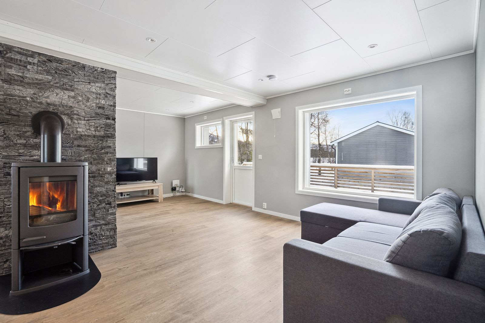 Romslig stue med vedfyring.