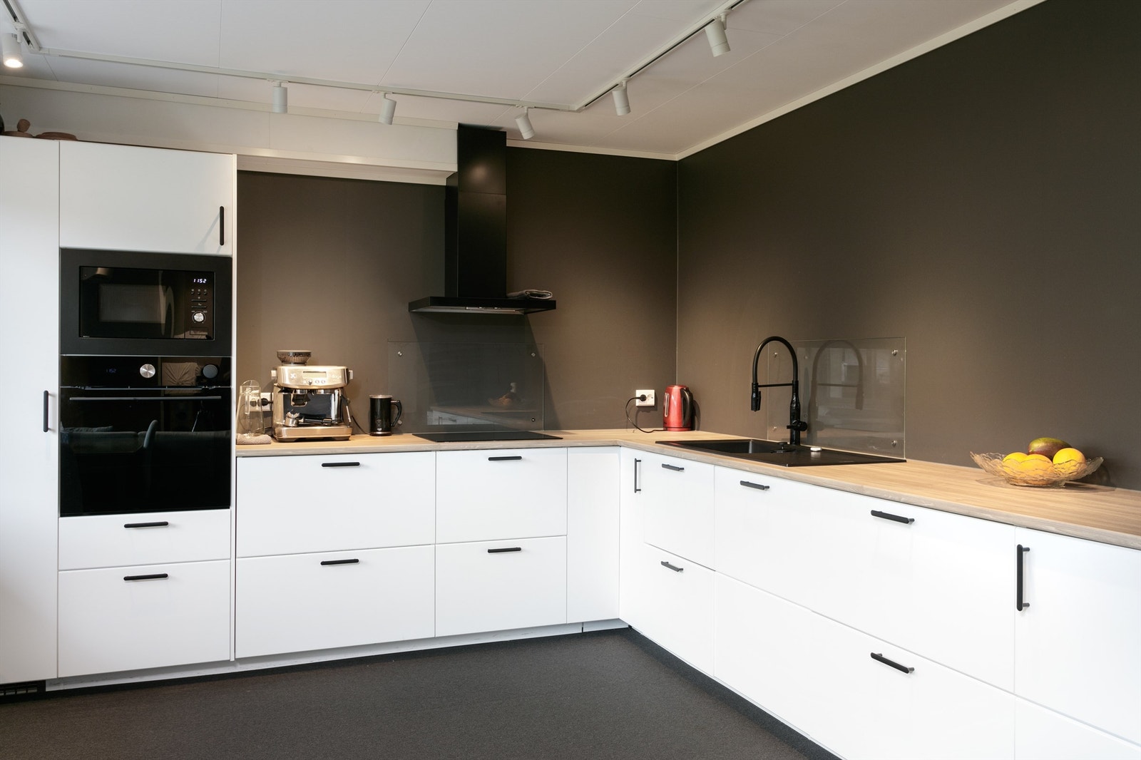 Ikea kjøkkeninnredning fra 2021 med laminat benkeplate. Nedfelt oppvaskkum, integrert kombi/damp/stekeovn, platetopp, oppvaskmaskin, mikrobølgeovn og kjøleskap. Vegghengt ventilator med komfyrvakt. Glassplate montert bak oppvaskkum og koketopp. Galleribilde