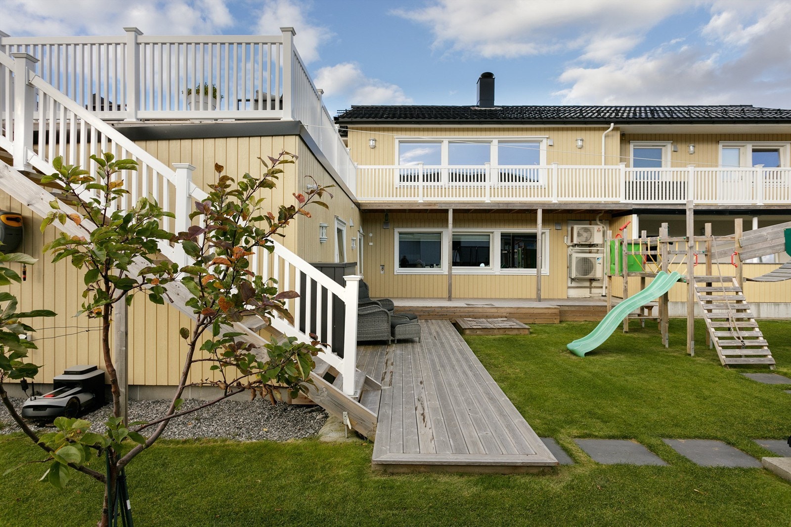 Det er adkoms fra terrassen i hovedetasjen til markterrasse og pent opparbeidet og beplantet hage Galleribilde