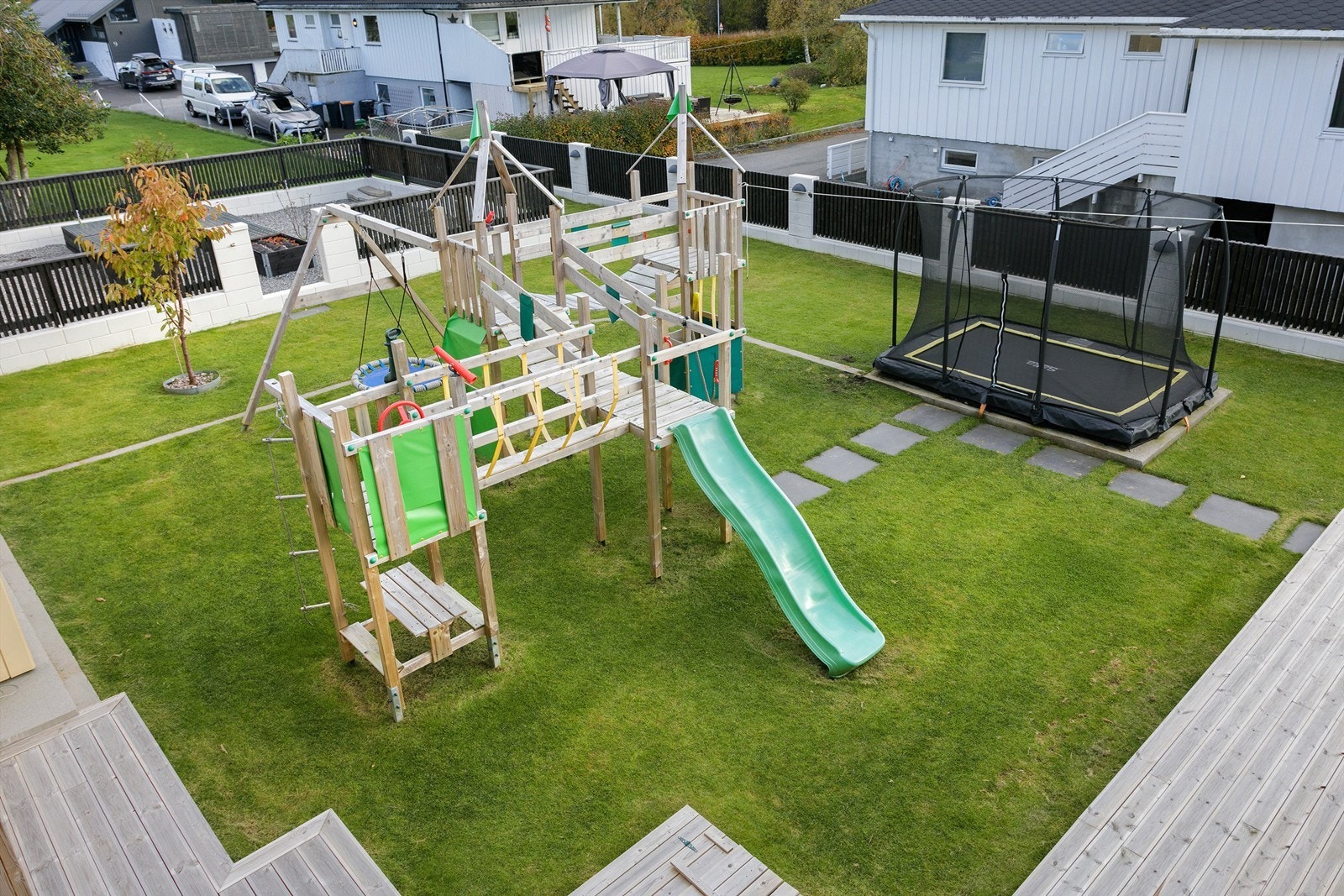 Meget barnevennlig hage med store lekeapparater og nedfelt tramponline - skjermet med gjerde mot naboer Galleribilde