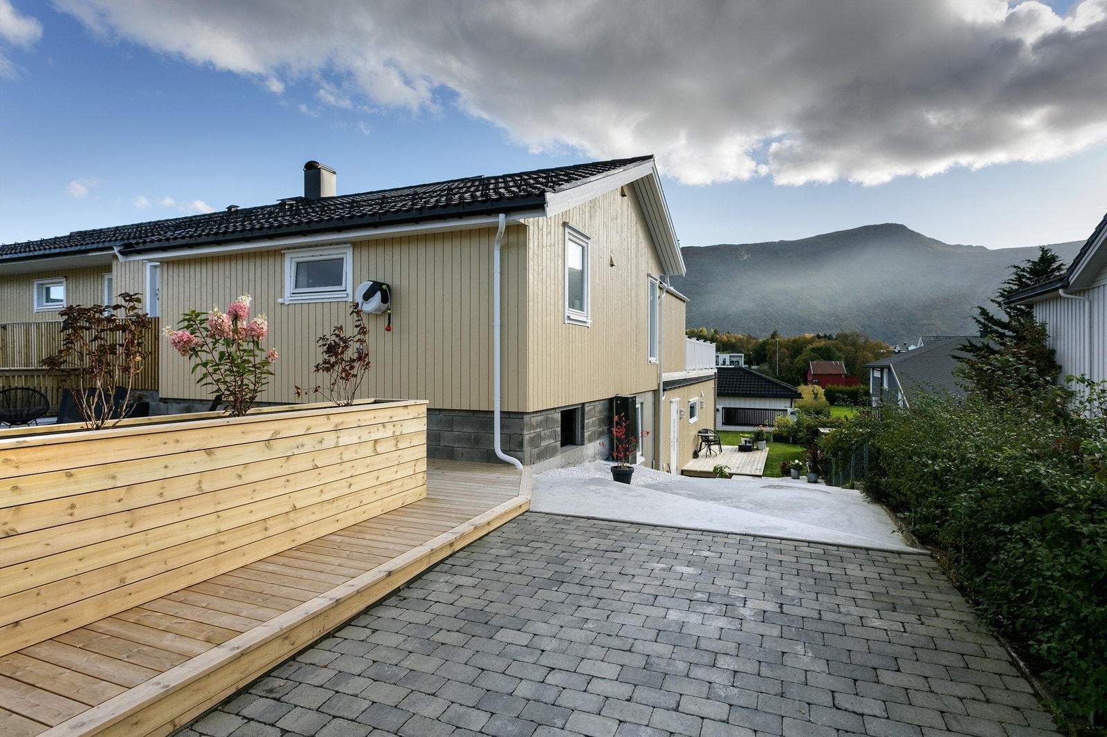 Meget pent opparbeidet tomt med store terrasser med plassbygde blomsterkasser samt steinlagte uteområder Galleribilde