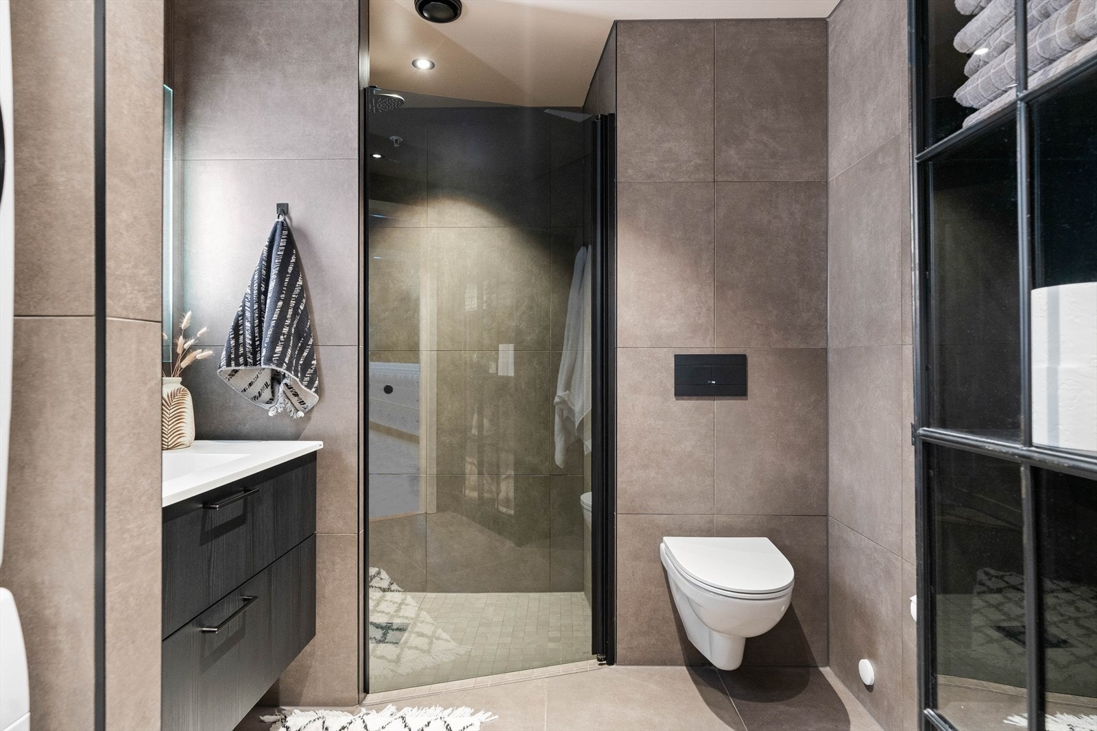 Det mørkflisede badet skaper en luksuriøs spafølelse i eget hjem. Galleribilde