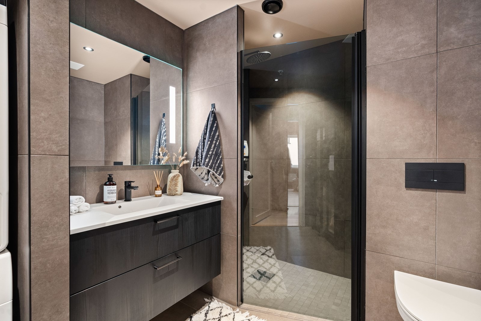 Delikat baderom med tidløse fliser på vegger og gulv. Galleribilde