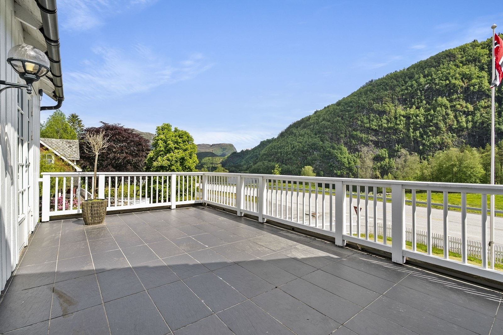 Stor, flislagd terrasse med tilkomst frå tømra stova Galleribilde