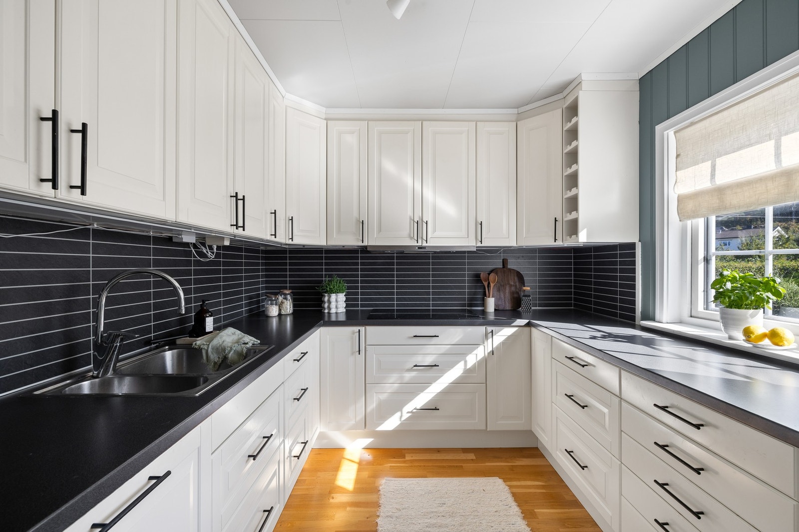 Kjøkkenet utstyrt med integrerte hvitevarer som oppvaskmaskin, kjøleskap, mikrobølgeovn, stekeovn og induksjonstopp, samt ventilator, benkestikk og god arbeidsbelysning Galleribilde