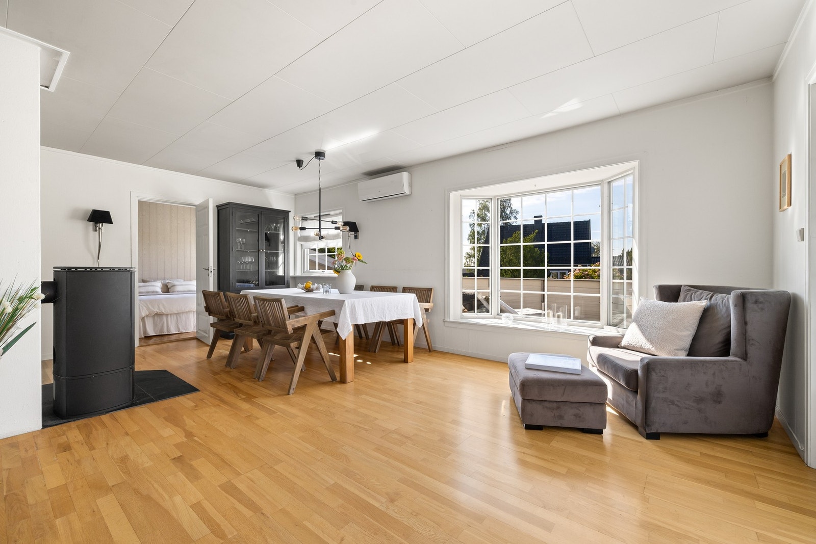 Stuen har gyllent, trestavs parkettgulv, og i tillegg til en god peisovn har rommet en luft-til-luft varmepumpe Galleribilde