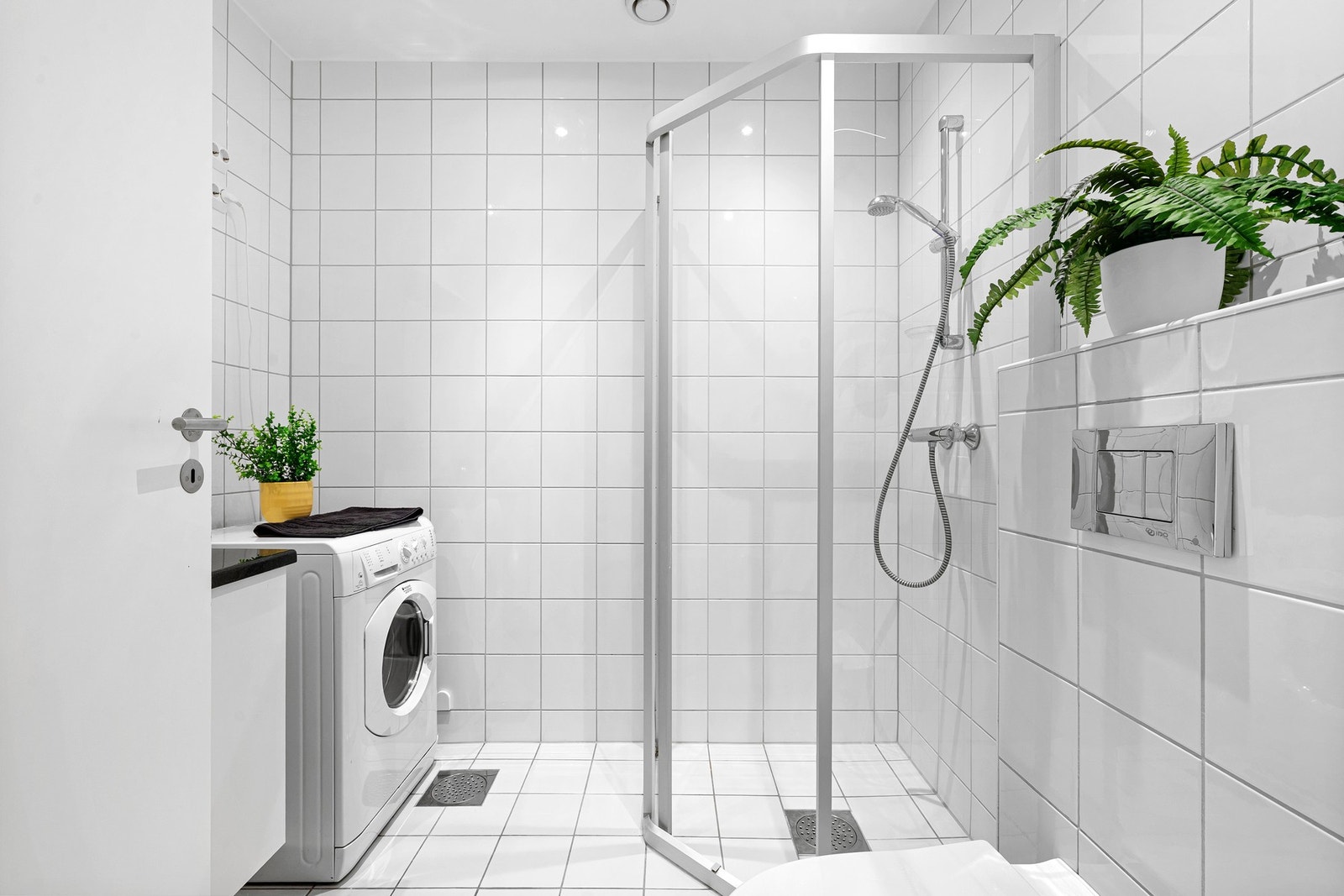 Stilrent, helfliset bad med romslig dusjhjørne og opplegg for vaskemaskin. Galleribilde