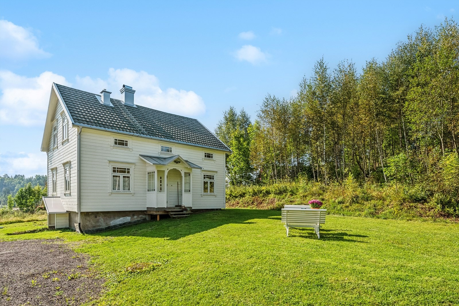 Ved boligens fasade retning nord finner vi et pent overbygget inngangsparti. Det er større hageområde med fine plenarealer som byr på godt med boltreplass. Galleribilde