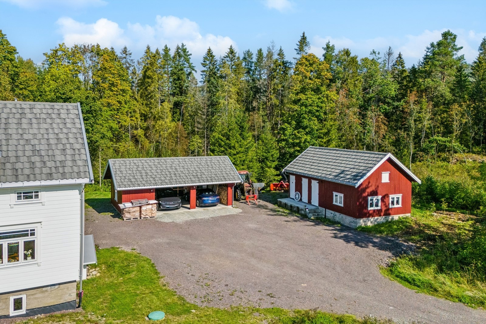Stor gruset gårdsplass med god plass for parkering. Det nylig bygget en dobbelgarasje/carport på eiendommen. Galleribilde