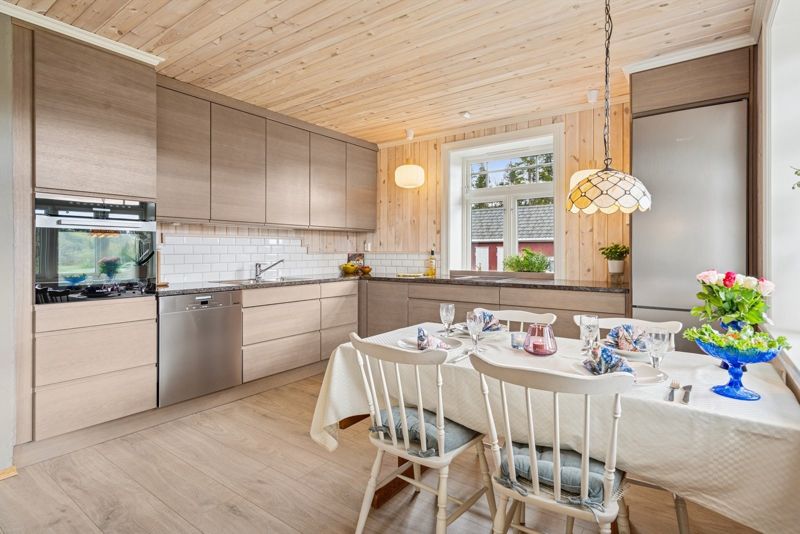 Kjøkkenet er lokalisert i åpen løsning mot stuen med montert lekker og moderne kjøkkeninnredning med lyse fronter levert fra Huseby. Påkostet benkeplate i stein sikrer en slitesterk og god overflate. Galleribilde