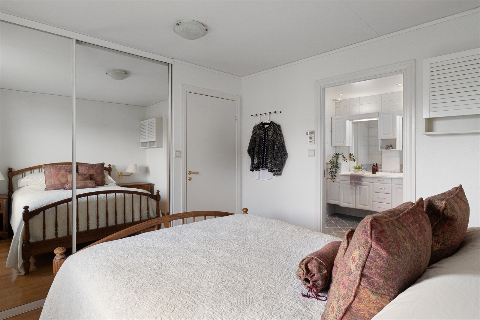 Her er det god plass til dobbeltseng, skyvedørsgarderobe med speil og direkte adkomst til badet Galleribilde