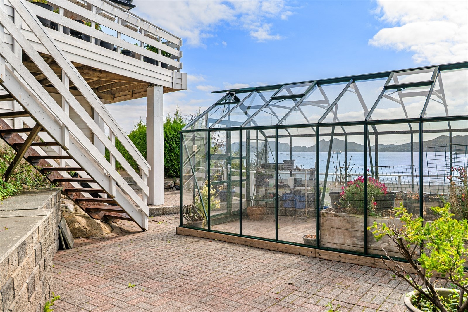 Eiendommen er meget pent opparbeidet med murer, belegningstein, stikkveier og blomsterbed Galleribilde