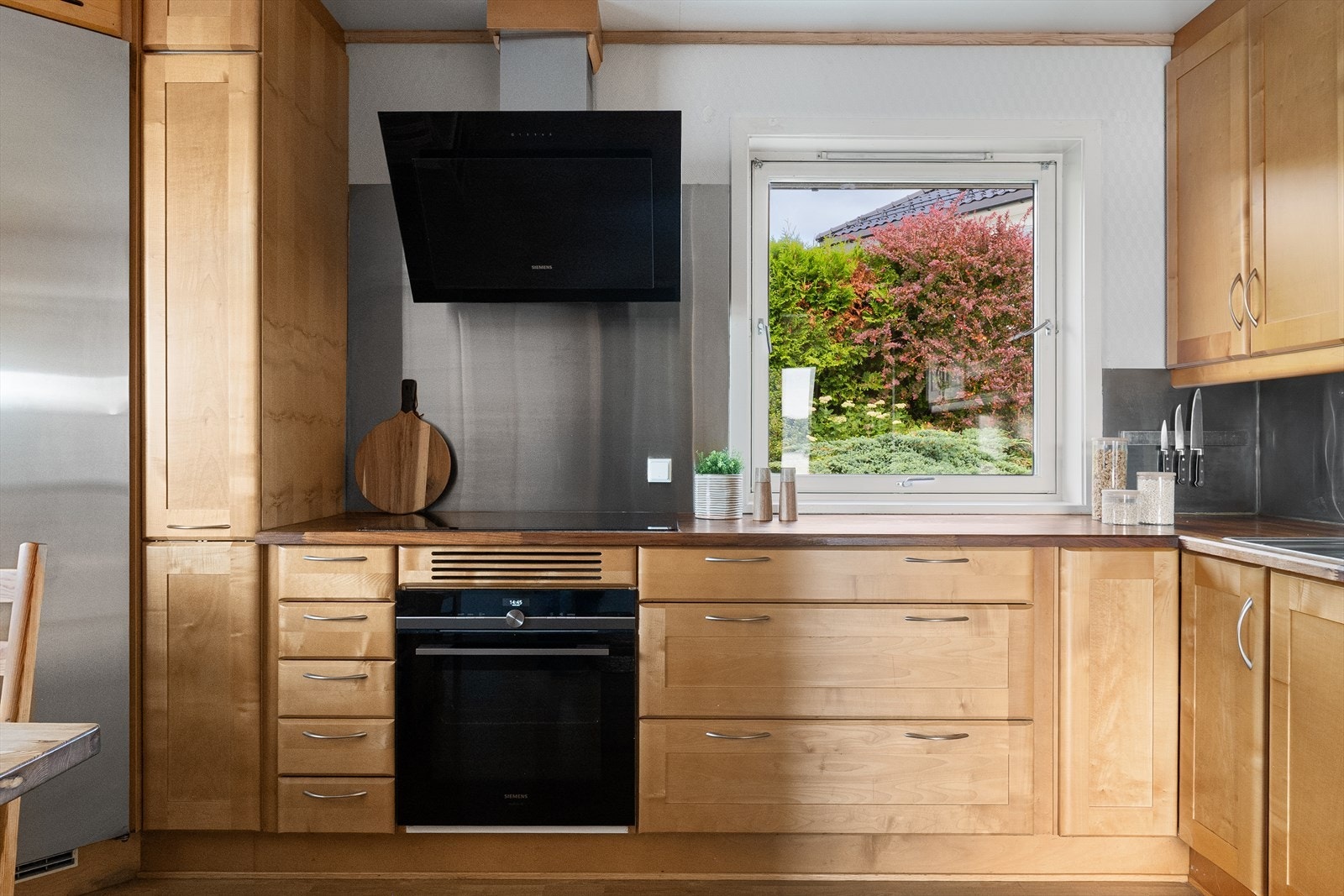 Kjøkkenet har profilerte fronter og benkeplater i tre, samt rikelig med både skap- og benkeplass Galleribilde