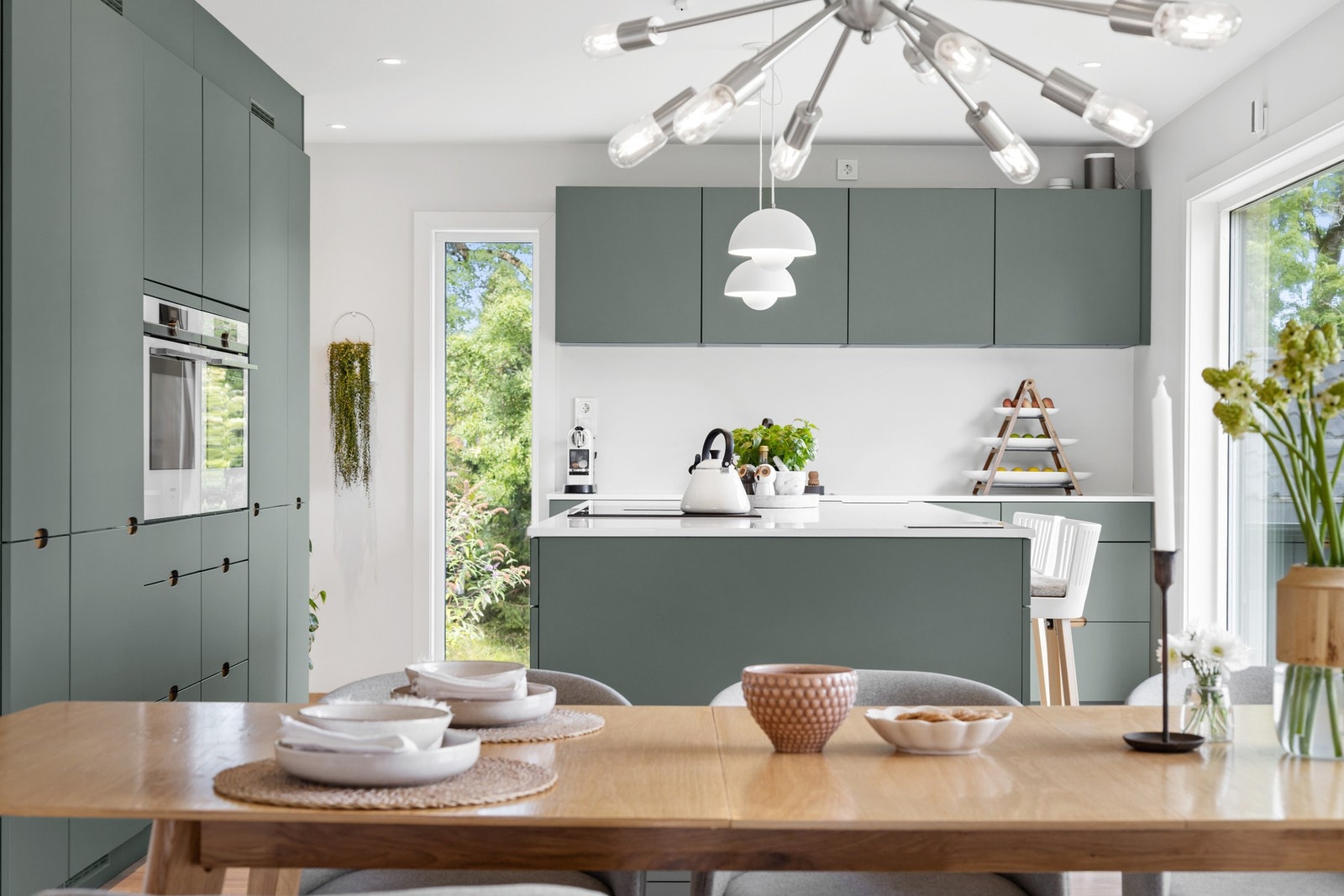 Stilrent Kvik-kjøkken fra 2021 med slette fronter og benkeplate i slitesterk kompositt Galleribilde