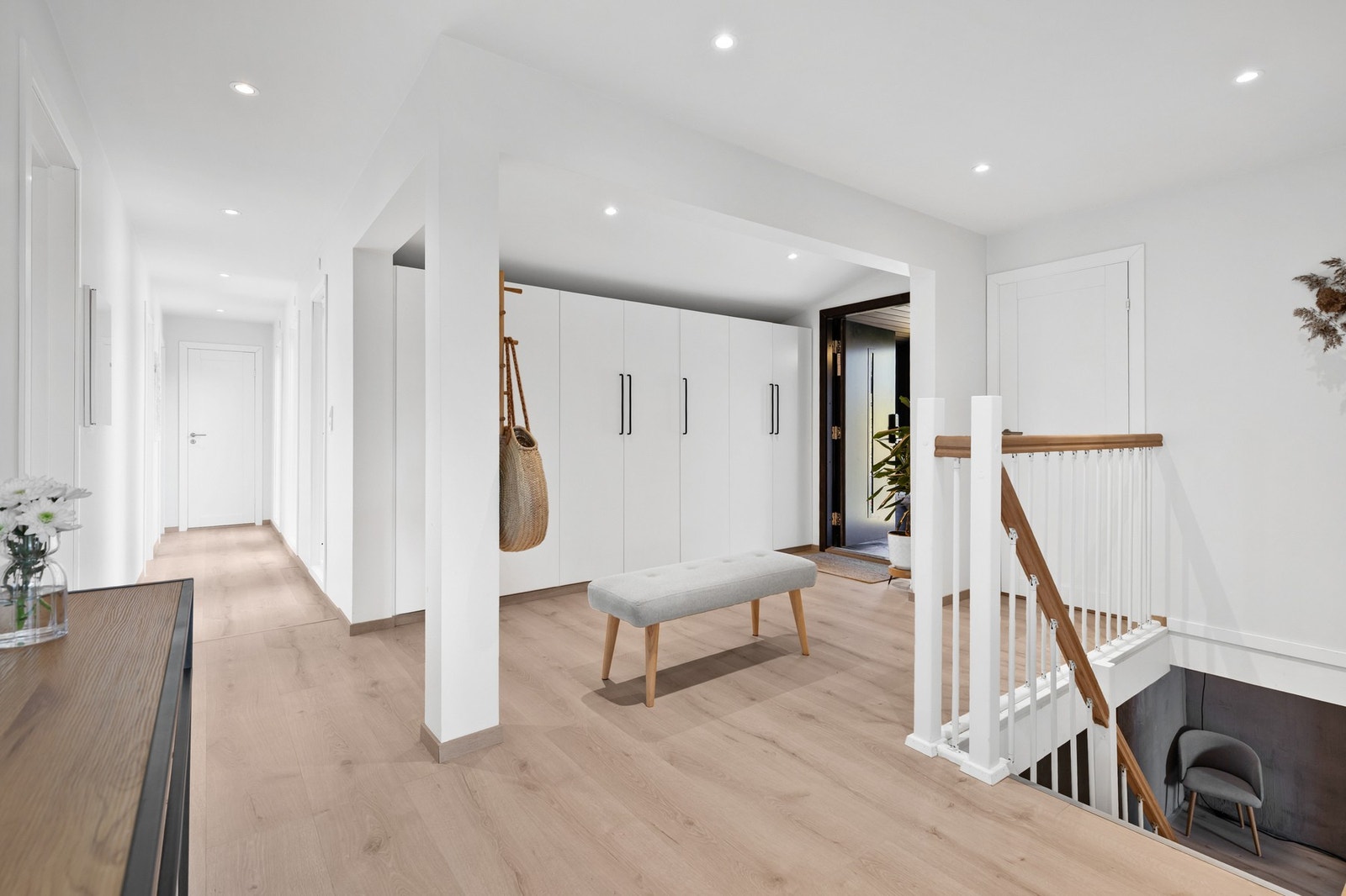 Lys og luftig entré med laminatgulv, slette flater på vegger og downlights i himling Galleribilde