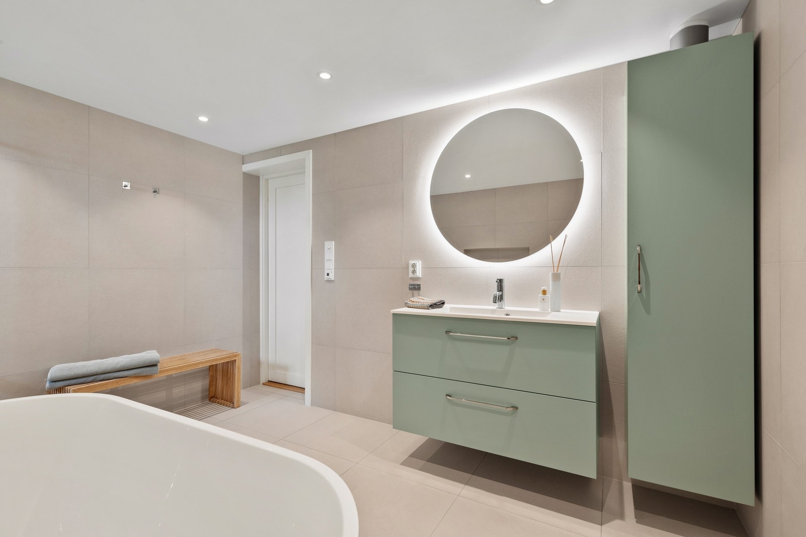 Lekkert, helfliset bad fra 2022 med baderomsinnredning og rundt speil med integrert belysning Galleribilde