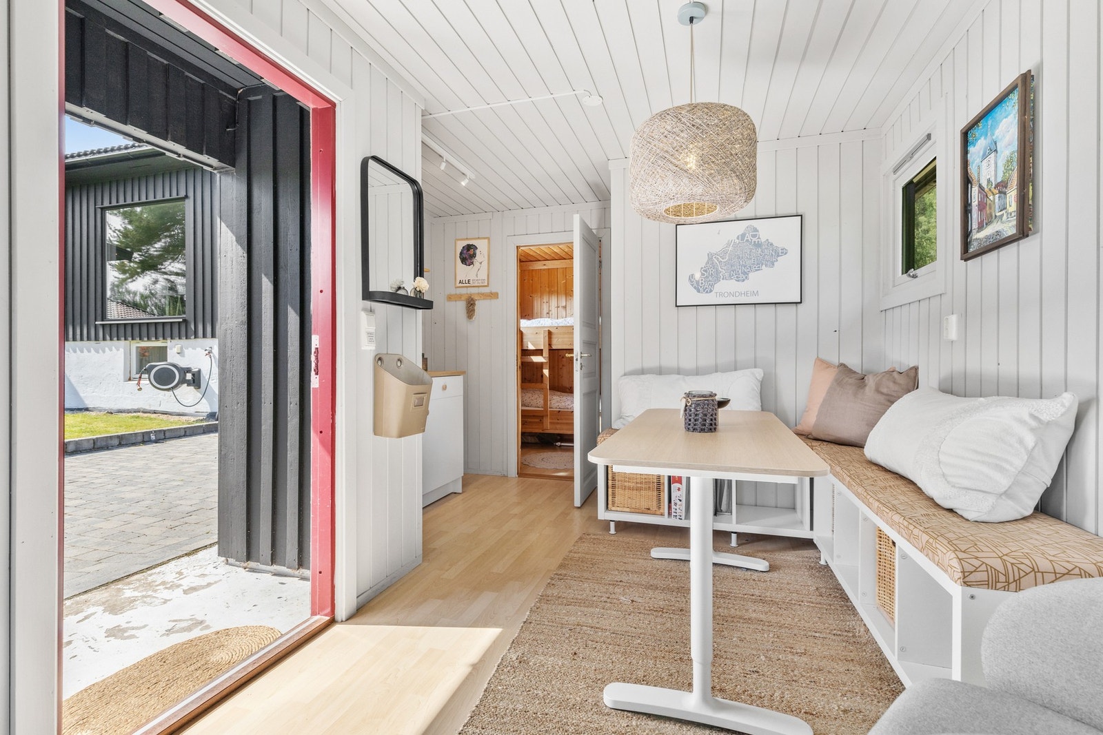 Hyggelig stue med laminat på gulv og malt trepanel på vegger og i himling Galleribilde