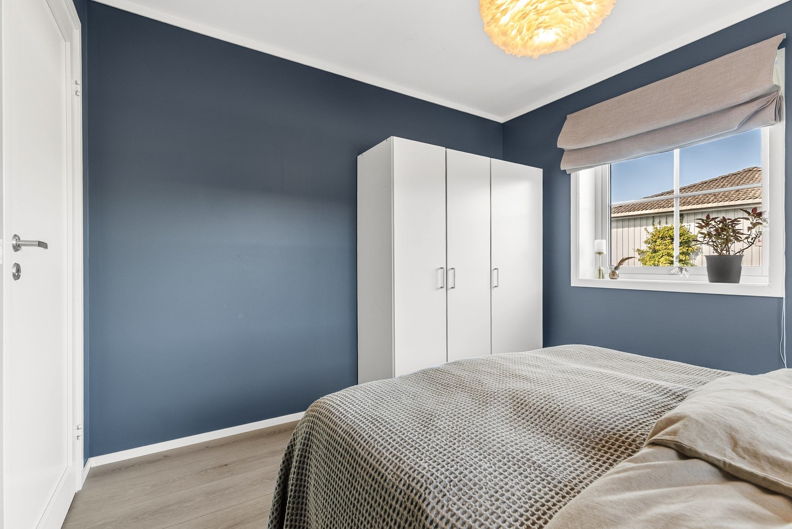 Hovedsoverommet har laminatgulv og mørkeblå vegger, samt fin plass til dobbeltseng, nattbord og garderobeskap Galleribilde