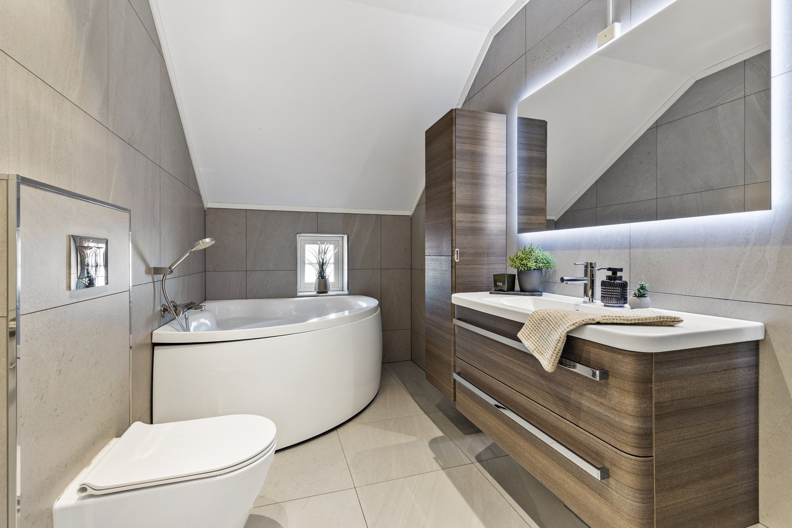 Helfliset bad utstyrt med servantinnredning, veggmontert toalett,
badekar og dusjhjørne Galleribilde