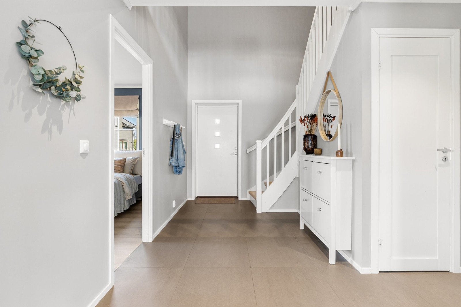 Luftig entré med fliser på gulv og slette flater på vegger Galleribilde