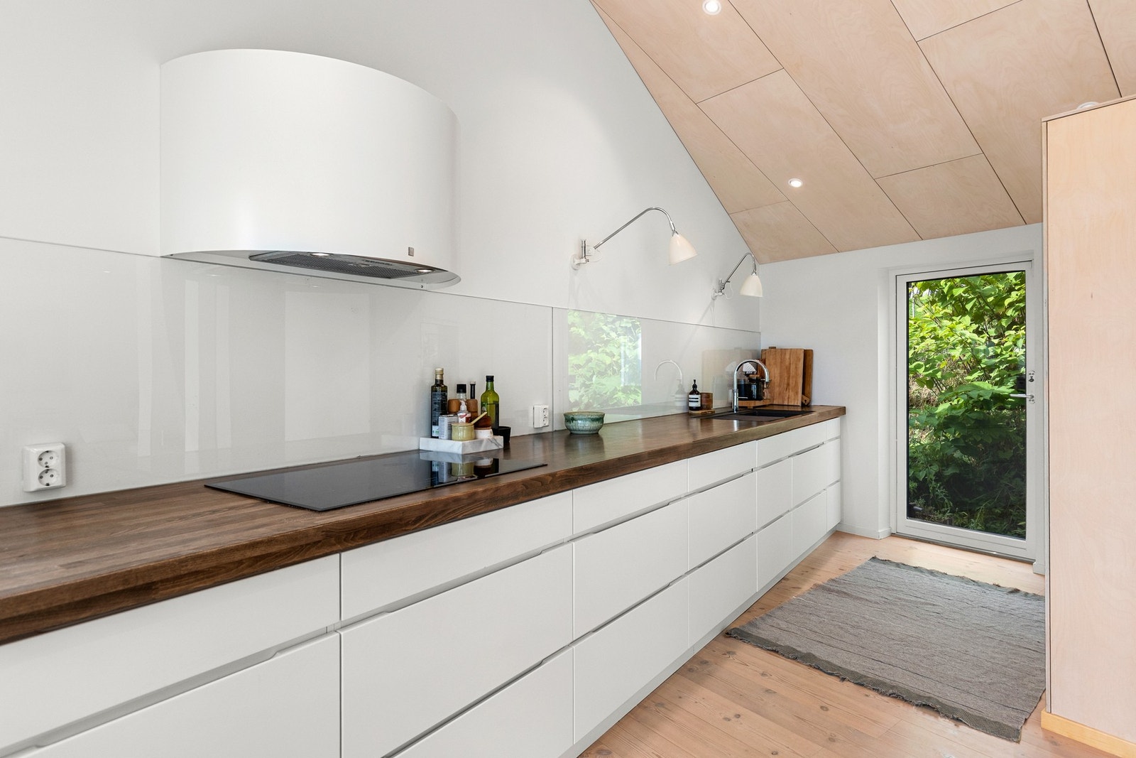 Kjøkkenet har et rent og minimalistisk uttrykk. Gode arbeidsflater og mye oppbevaringsplass i kjøkkeninnredningen. Galleribilde