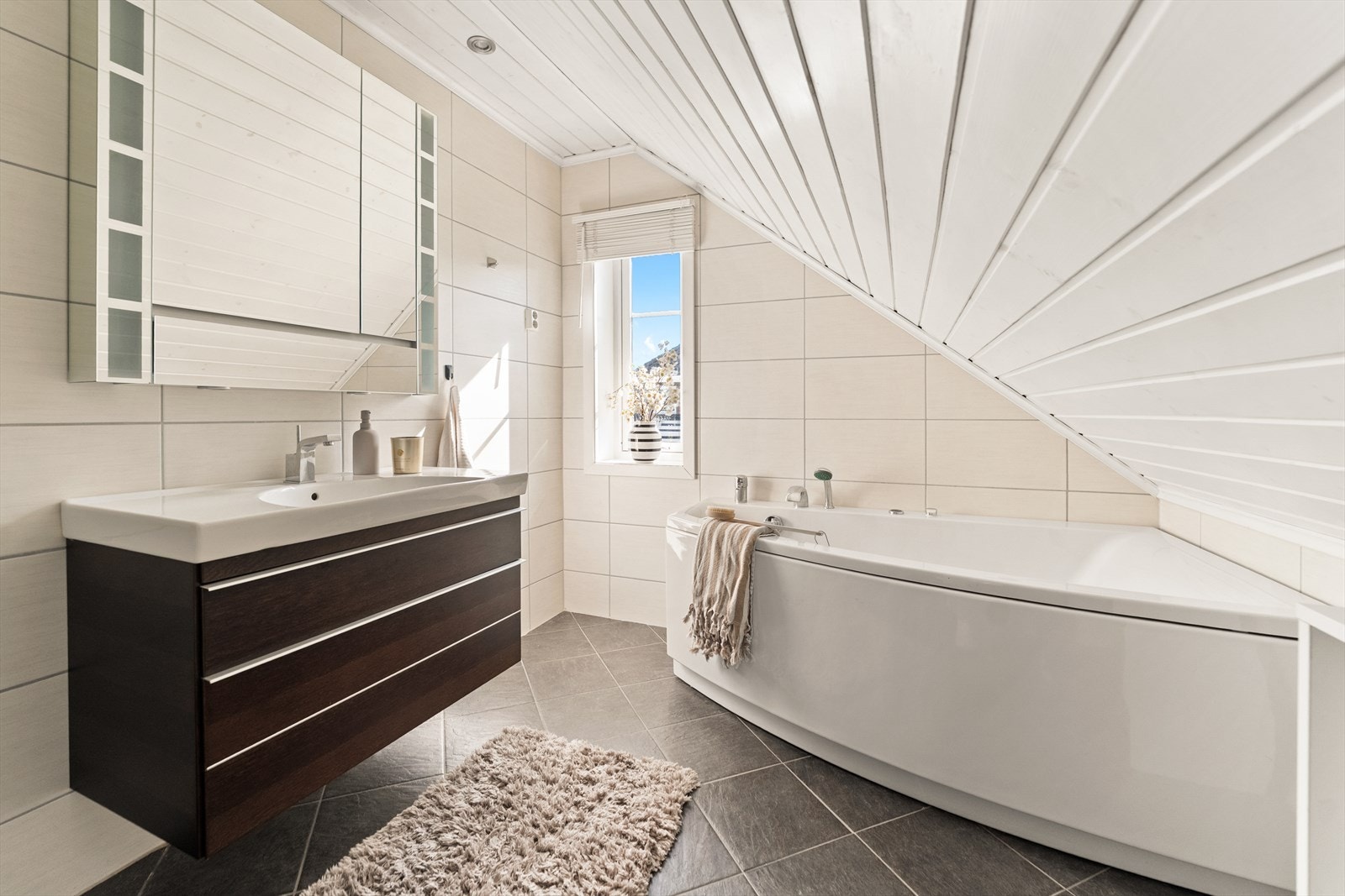 Baderommet i andre etasje er innredet med servant m/underskap, speil med tilhørende belysning, boblekar og gulvmontert toalett. Galleribilde