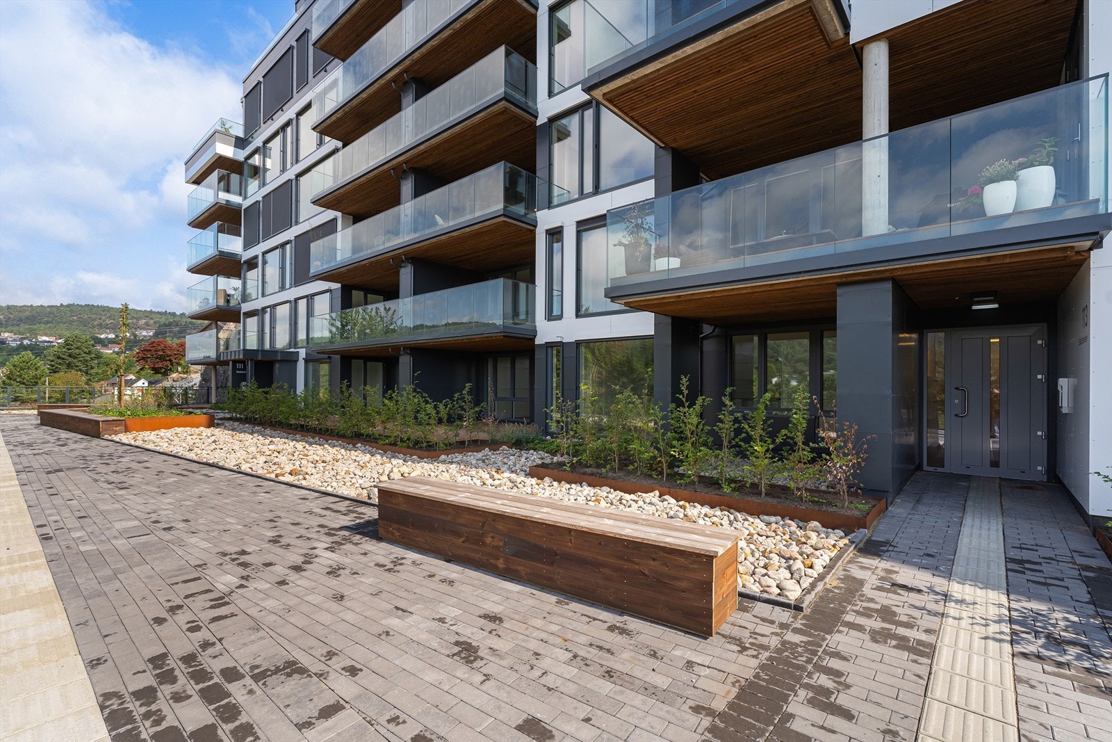 Inngangspartiet og området er pent opparbeidet med hyggelige sitteplasser og beplanting. Galleribilde