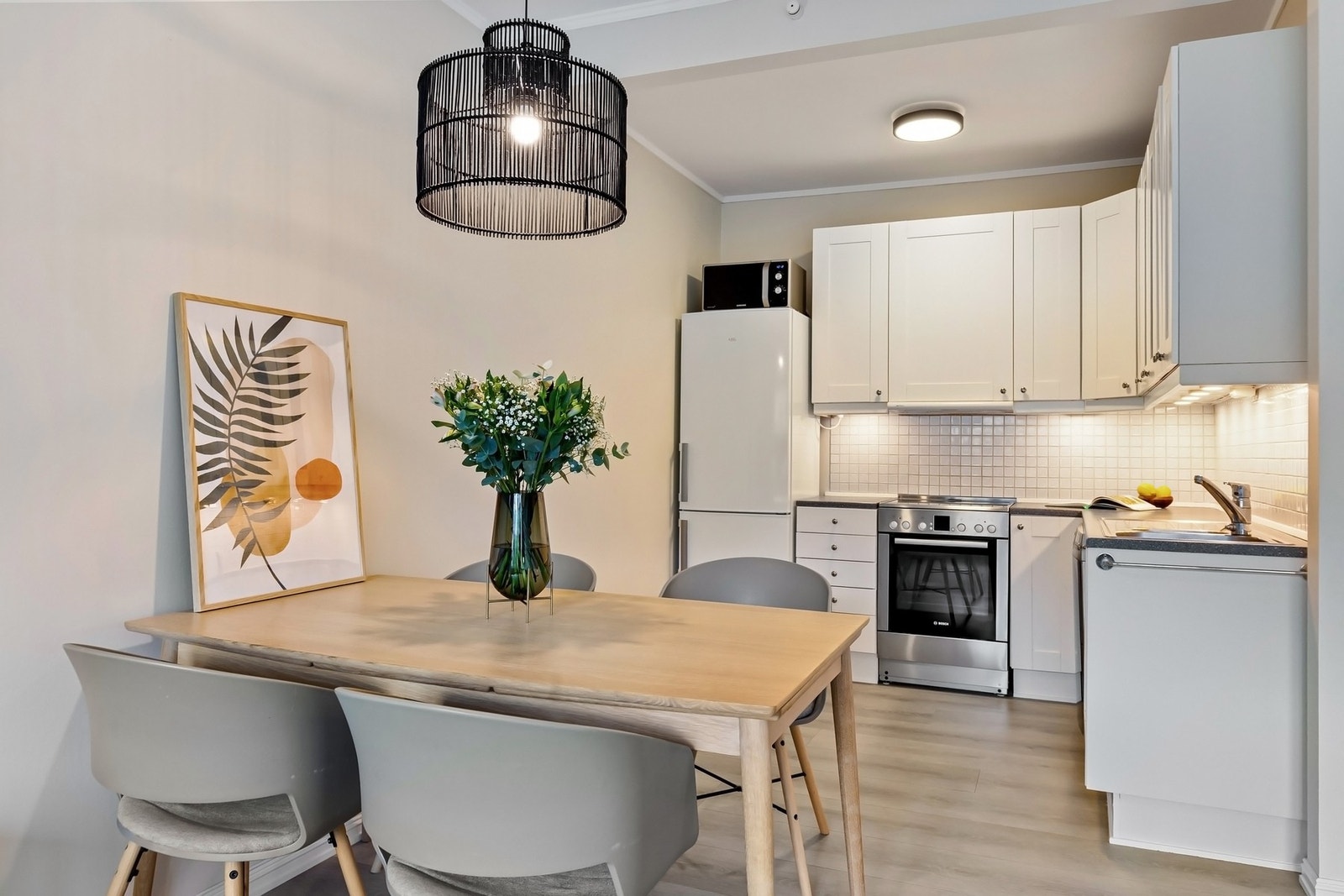 Tidløs kjøkkeninnredning i egen sone med moderne profilerte fronter og benkeplate i laminat. Galleribilde