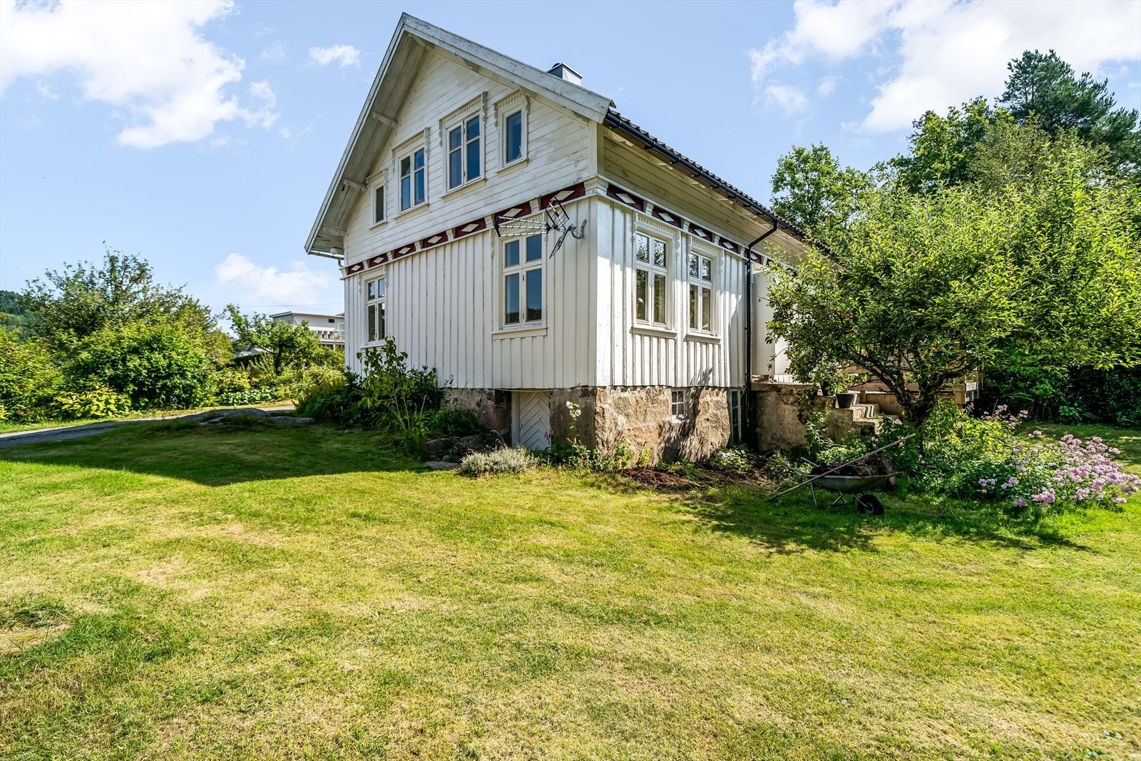 Hagen er fint beplantet med busker, trær, blomster og annen vegetasjon. Galleribilde