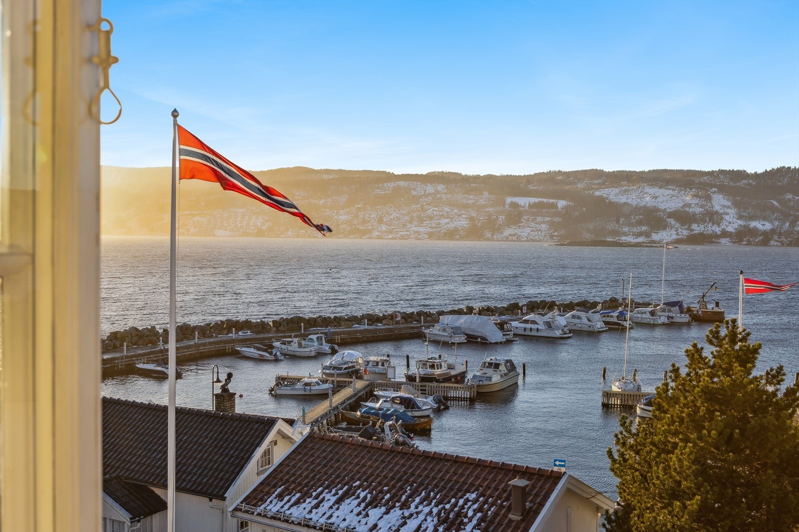 Flott utsikt over båthavna og sjøen fra loftstue. Galleribilde