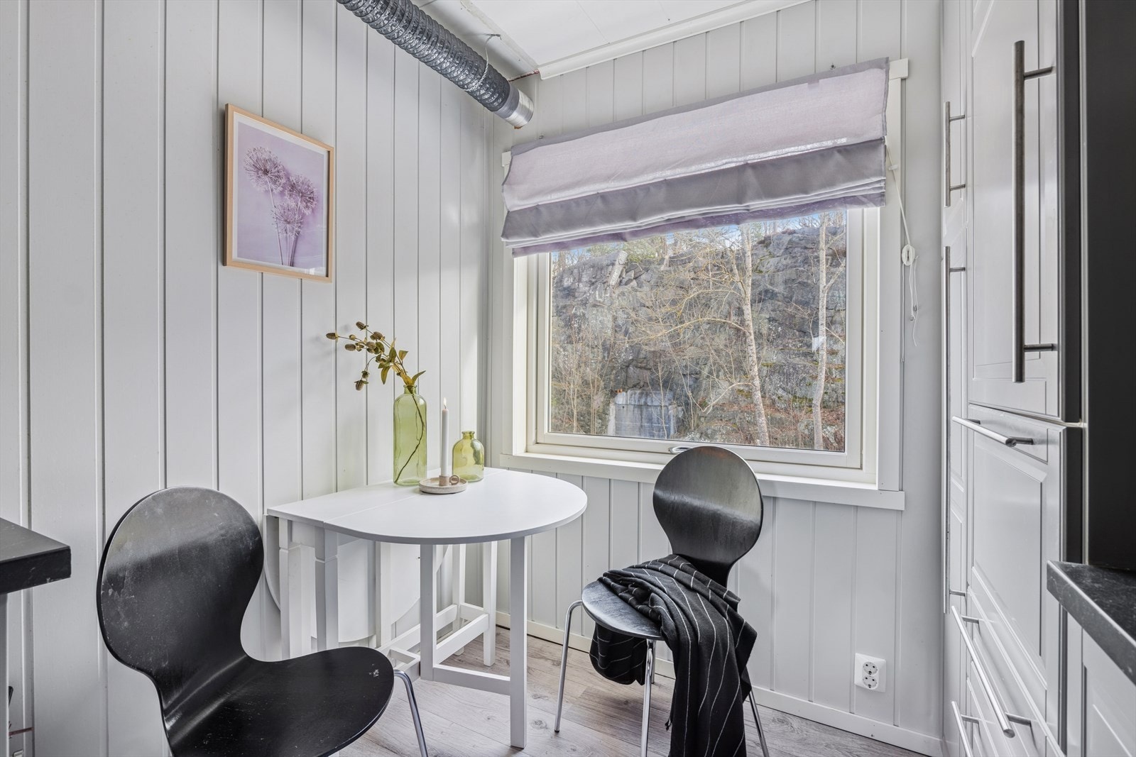 Kjøkkenet har plass til et lite spisebord foran vinduet Galleribilde