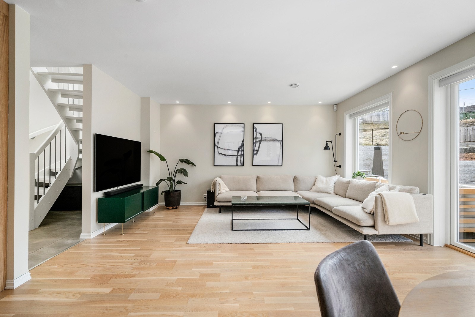 Vinduer langs hele ytterveggen gir naturlig lysinnslipp til hele rommet, samt hyggelig utsikt til terrassen utenfor. Galleribilde