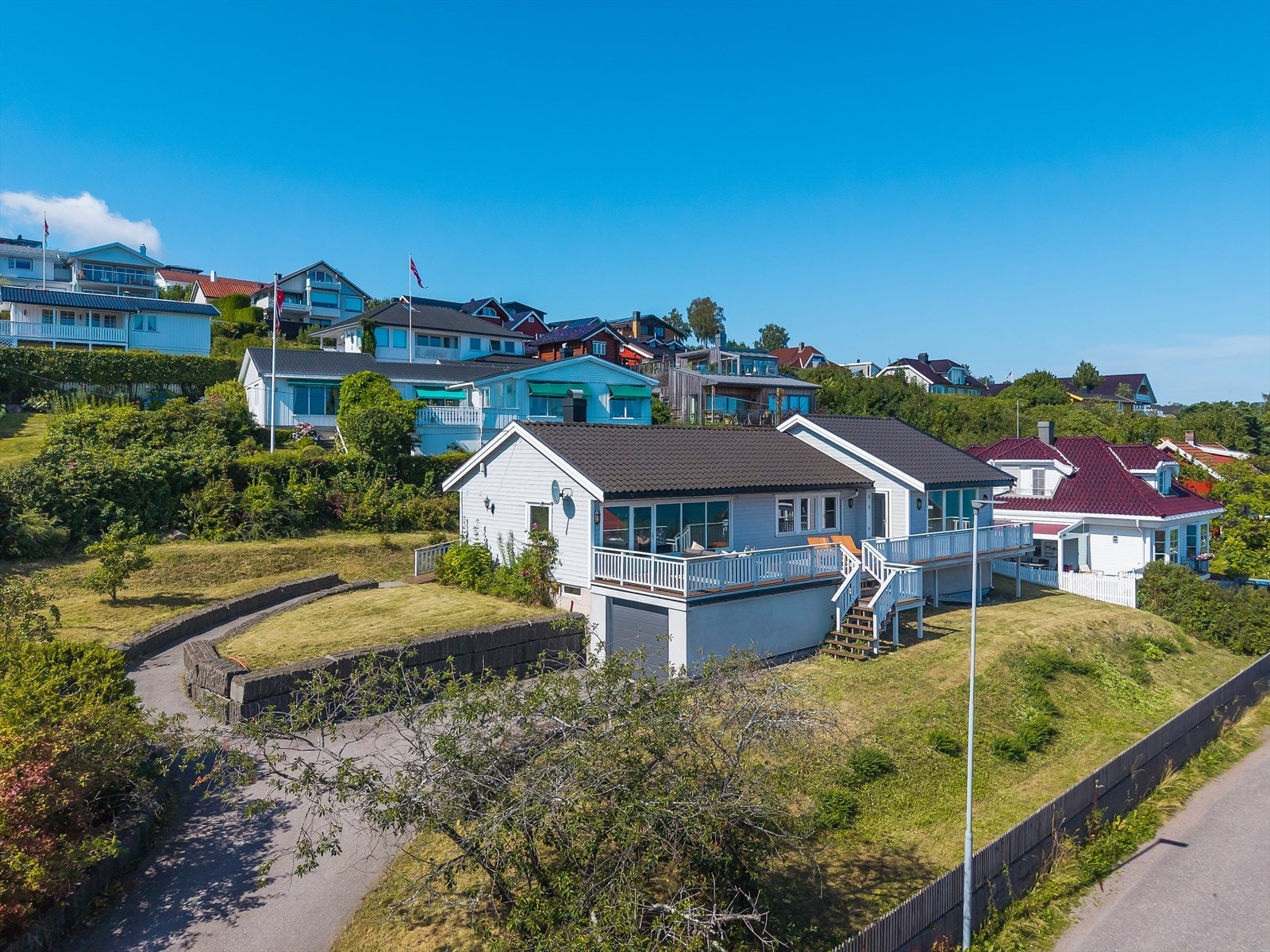 Asfaltert innkjørsel med parkering og garasje. Galleribilde