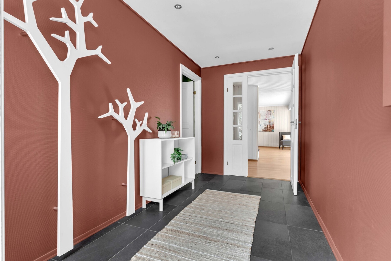 Entréen er praktisk utformet med mørke, slitesterke fliser - en ideell løsning for en aktiv hverdag når både store og små beveger seg inn og ut uavhengig av vær og føre. Galleribilde